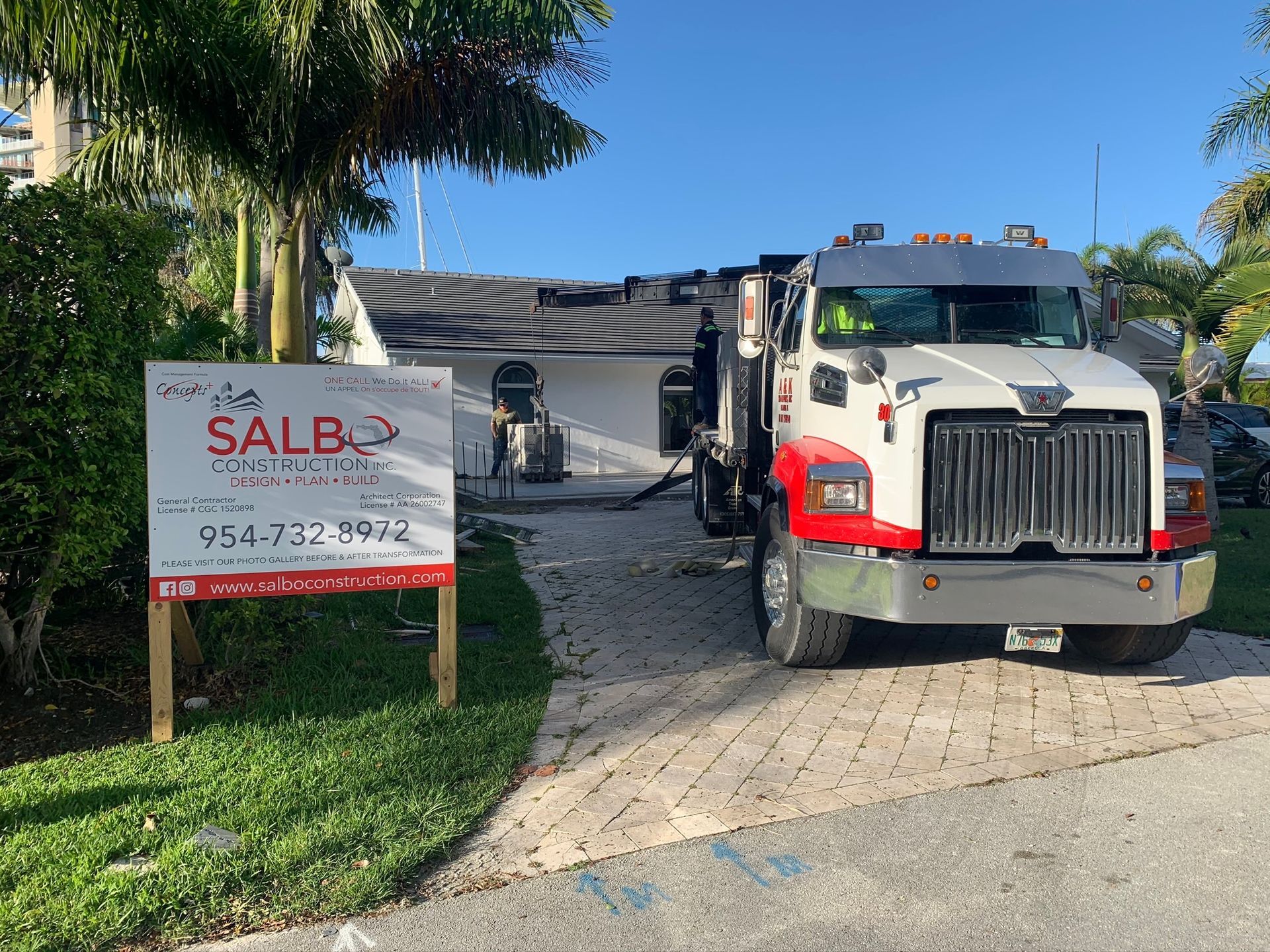 A truck is parked in front of a house with a sign in front of it.
