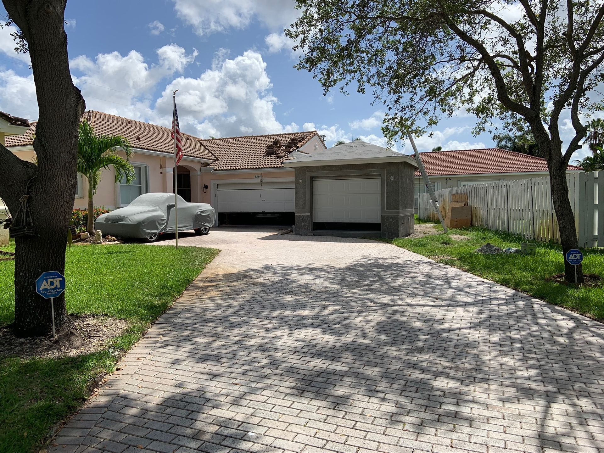 A car is parked in the driveway of a house.