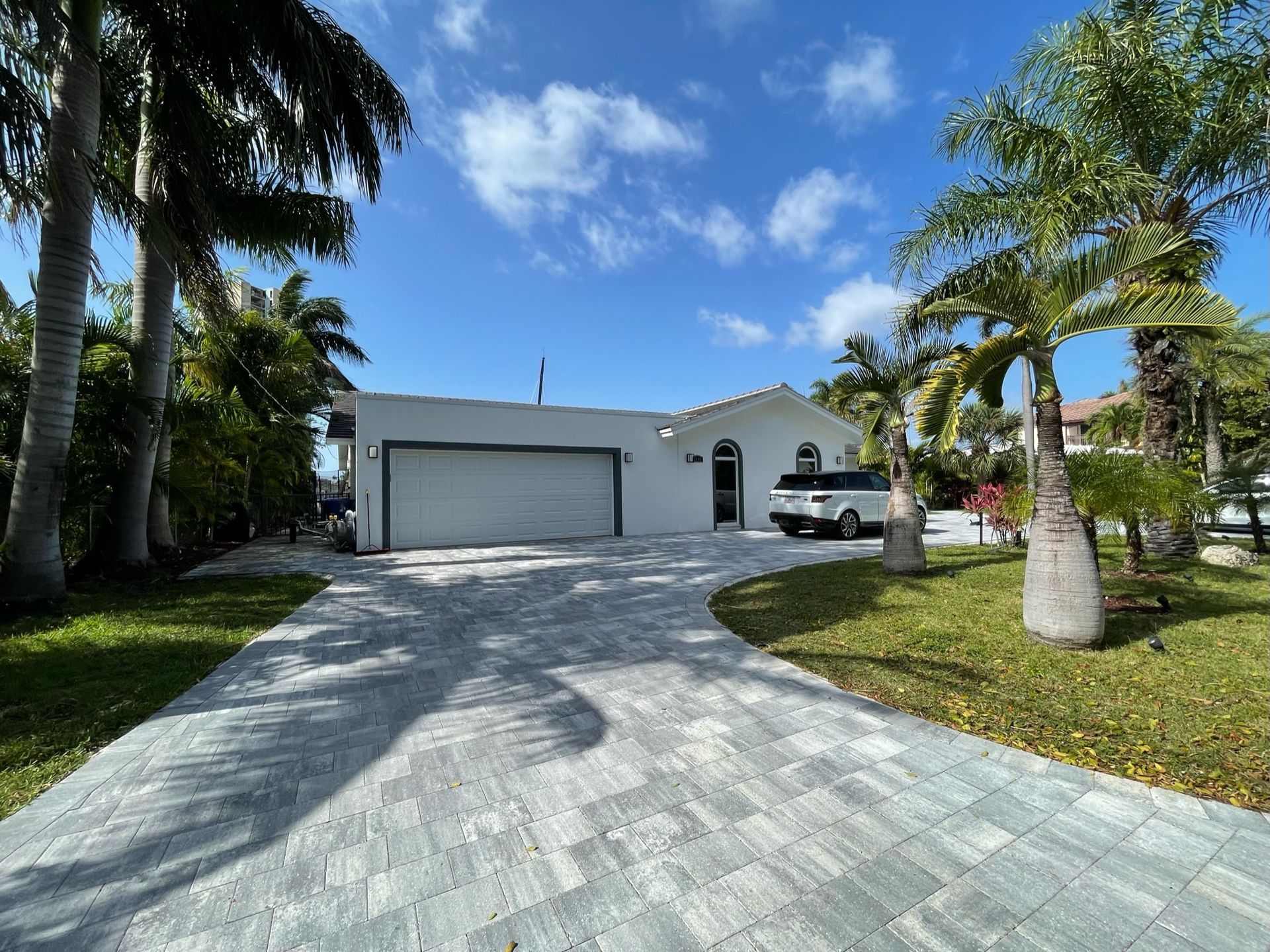 A white house with a car parked in front of it