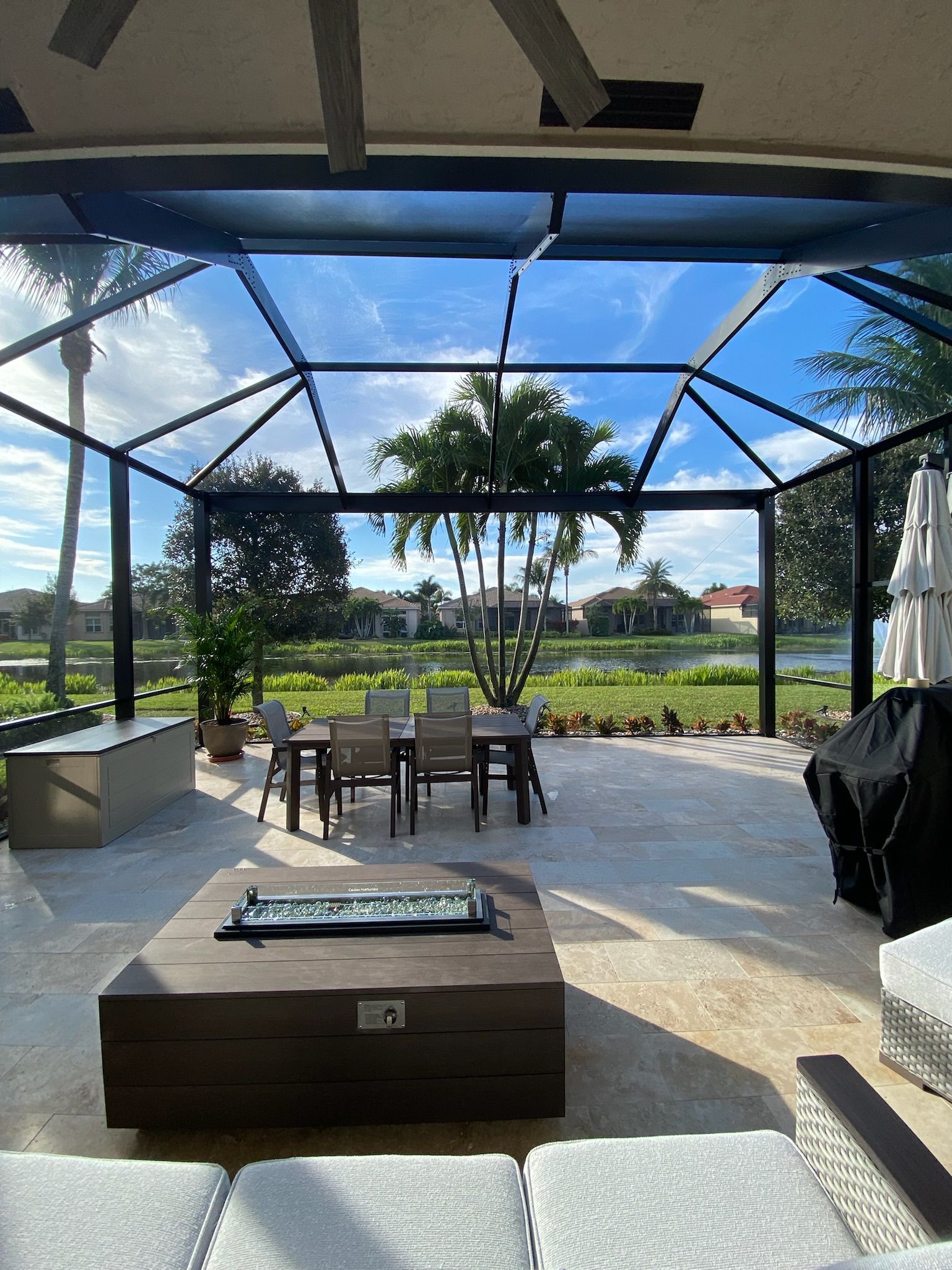 A patio with a table and chairs under a clear roof