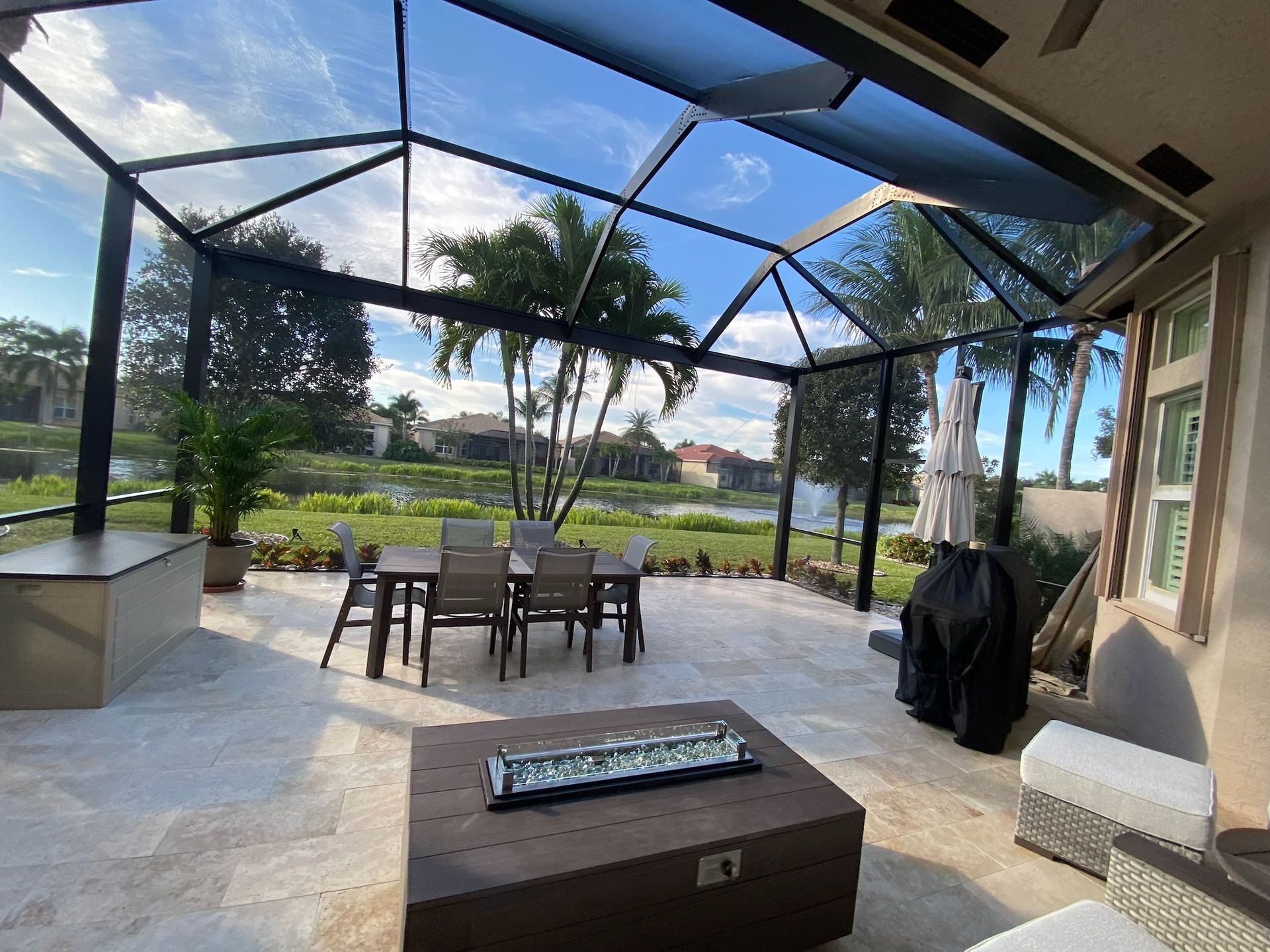 A patio with a table and chairs under a clear roof