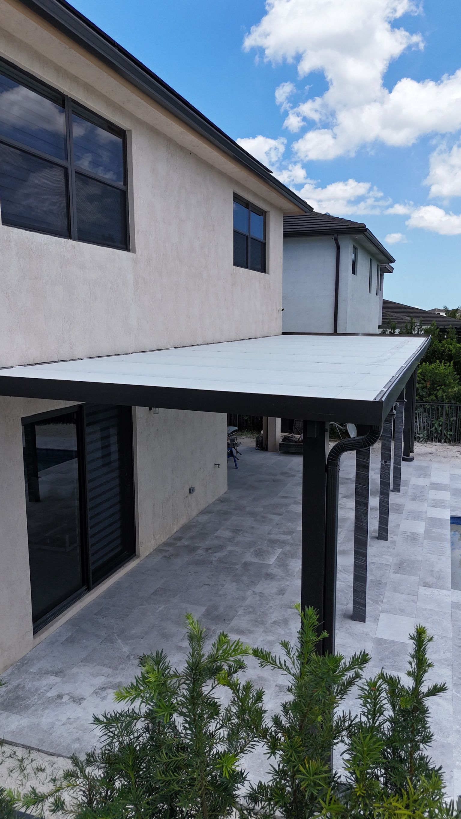 A house with a covered patio in front of it.
