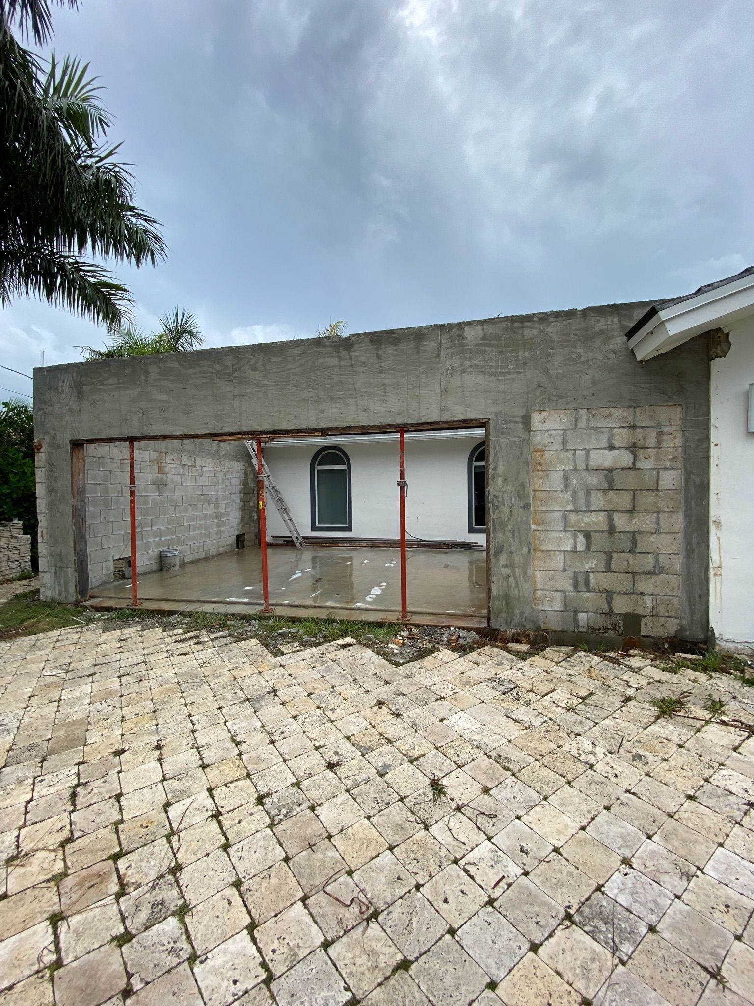 A white house with a brick driveway in front of it