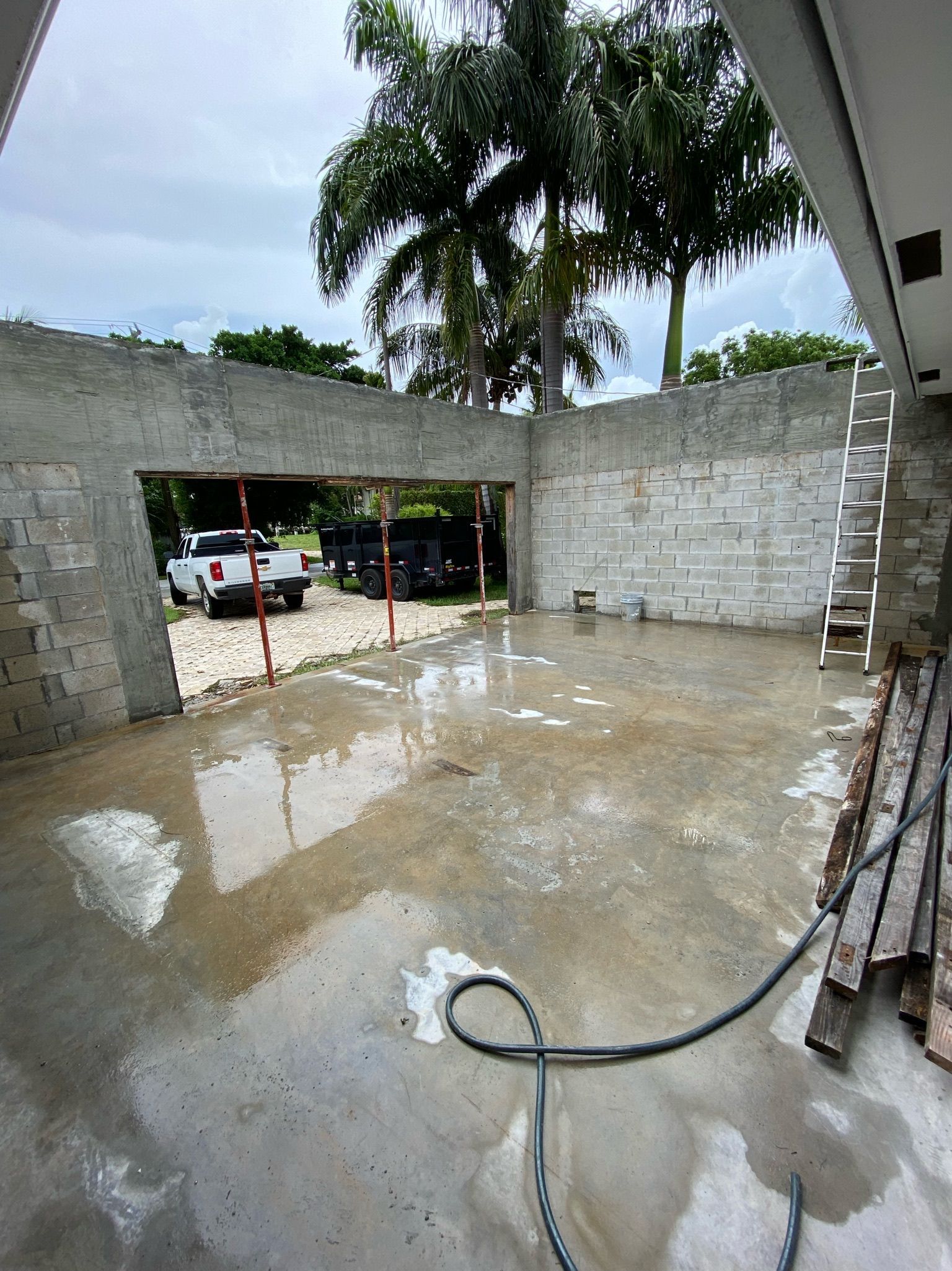 A white truck is parked in front of a building under construction.