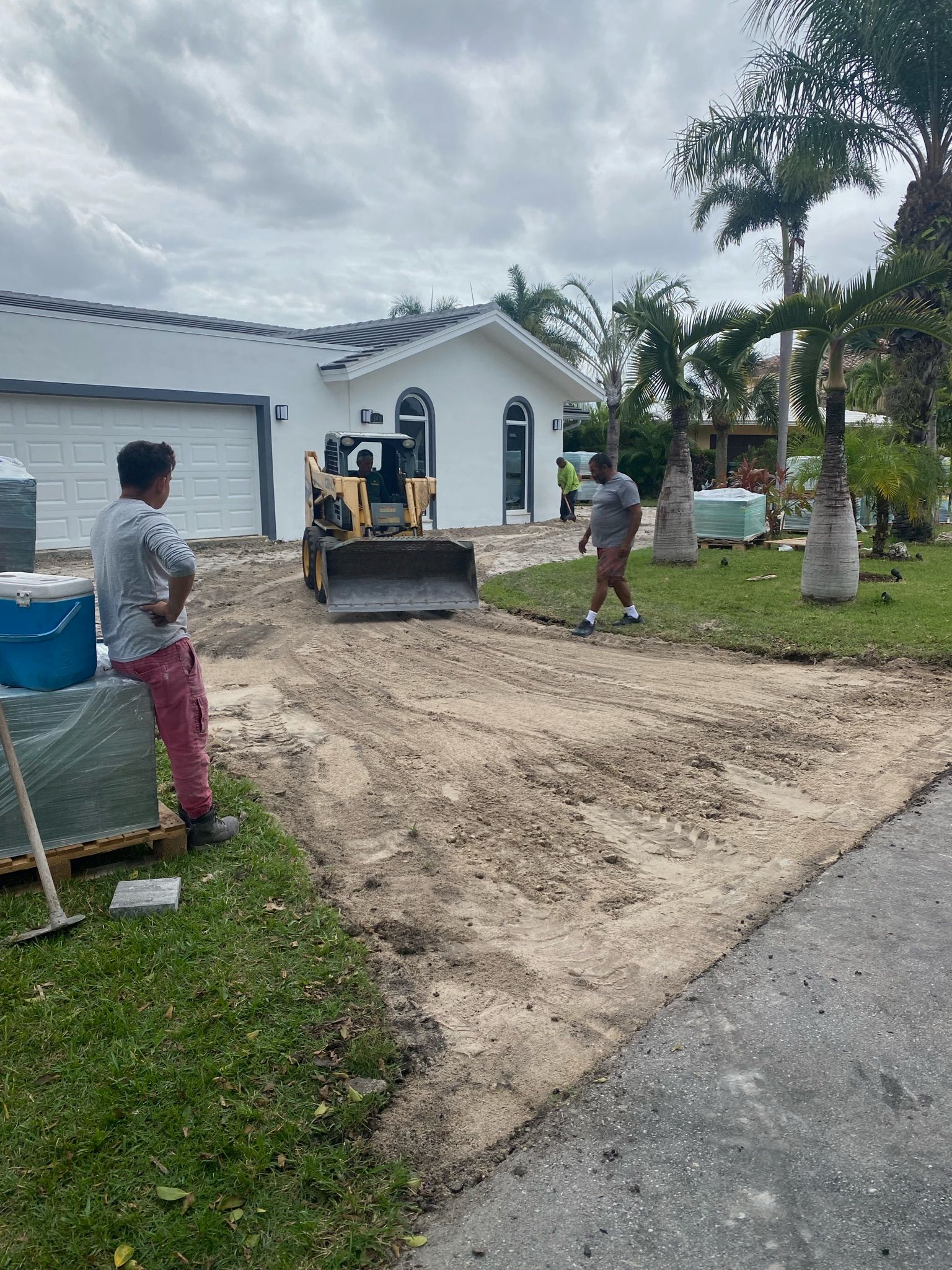 A bulldozer is moving dirt in front of a house.