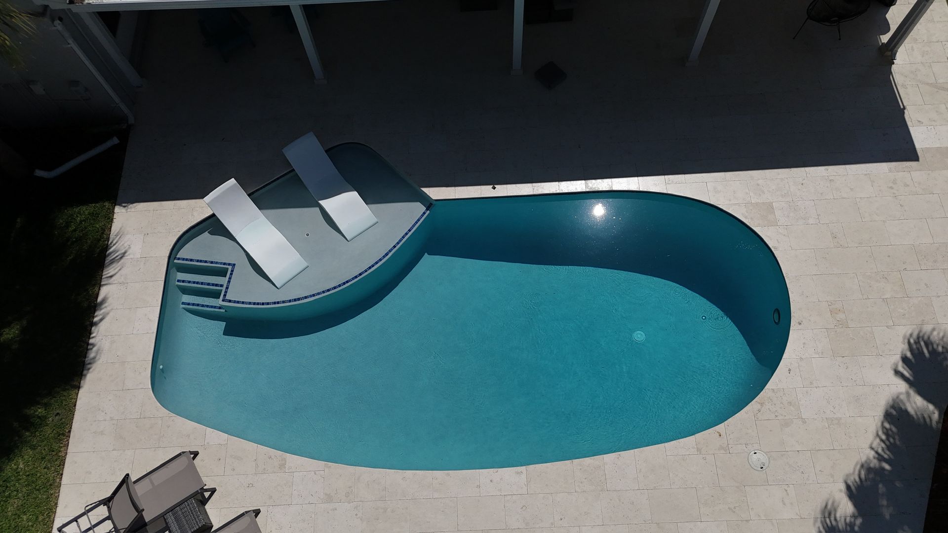 An aerial view of a swimming pool with two chairs in it