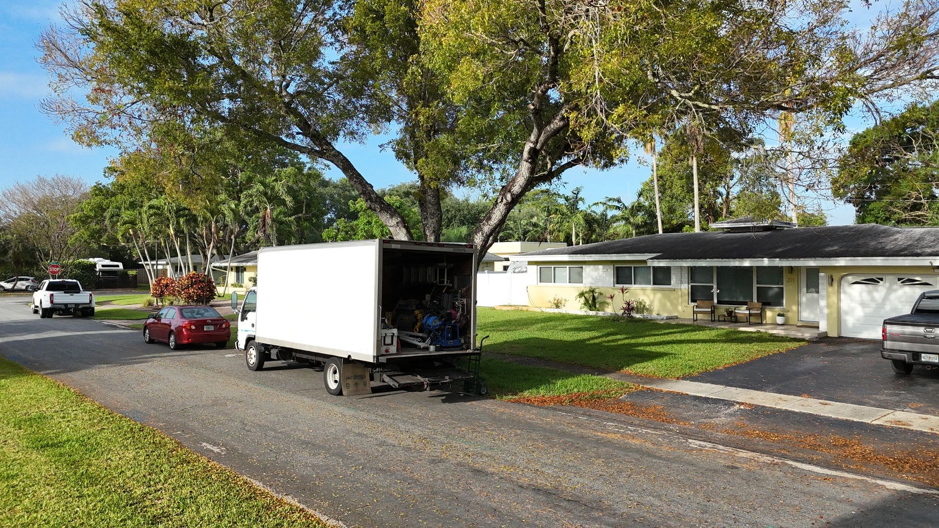 A white truck is parked in front of a house.