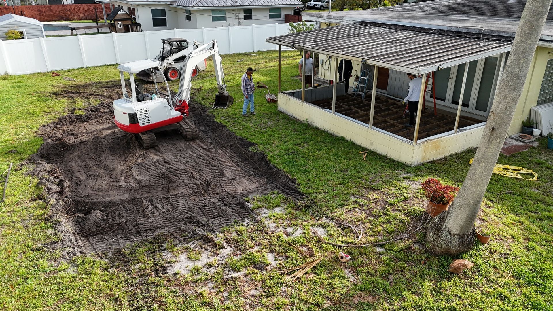 An aerial view of a construction site in front of a house.