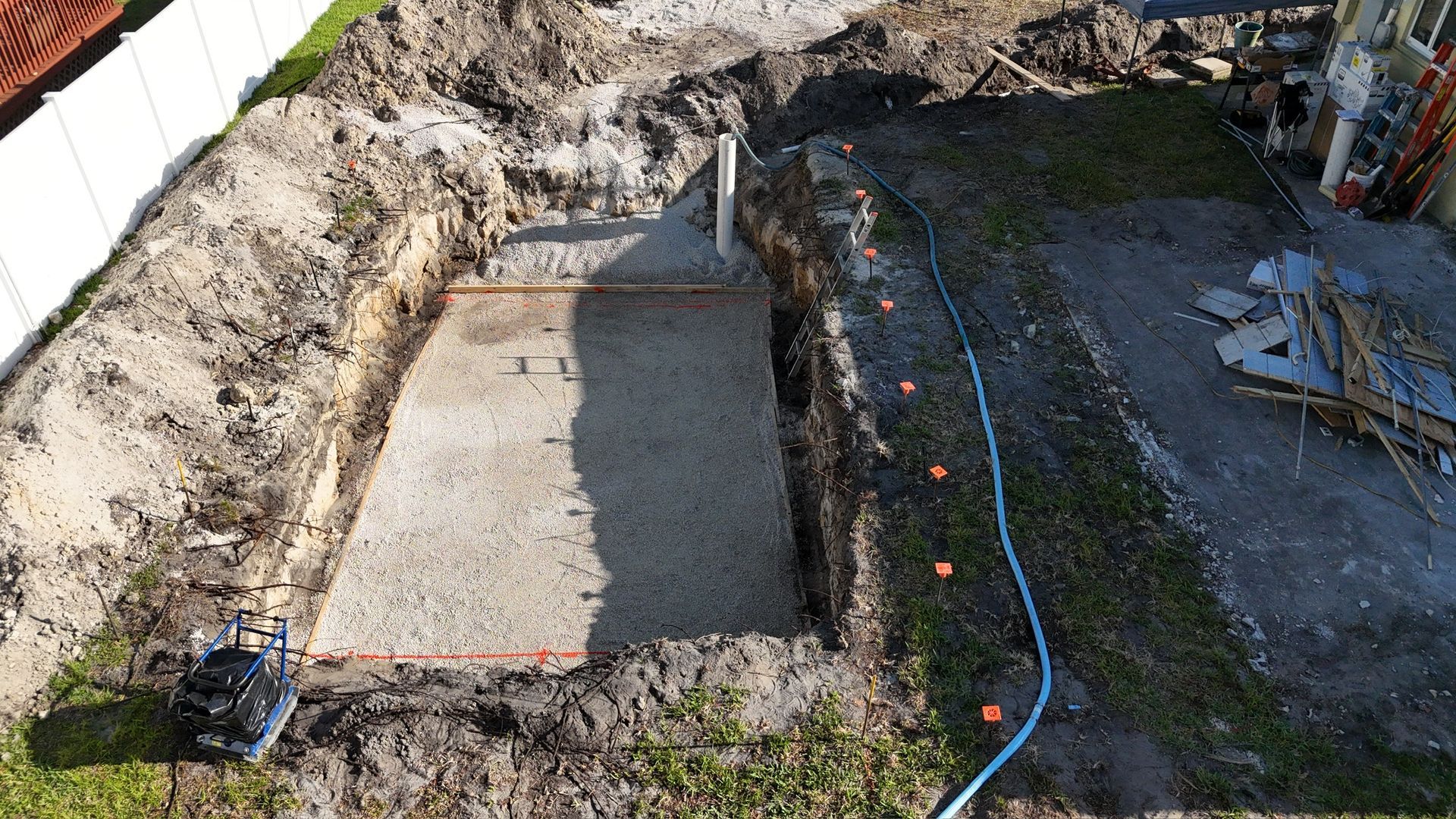 An aerial view of a swimming pool being built in a backyard.