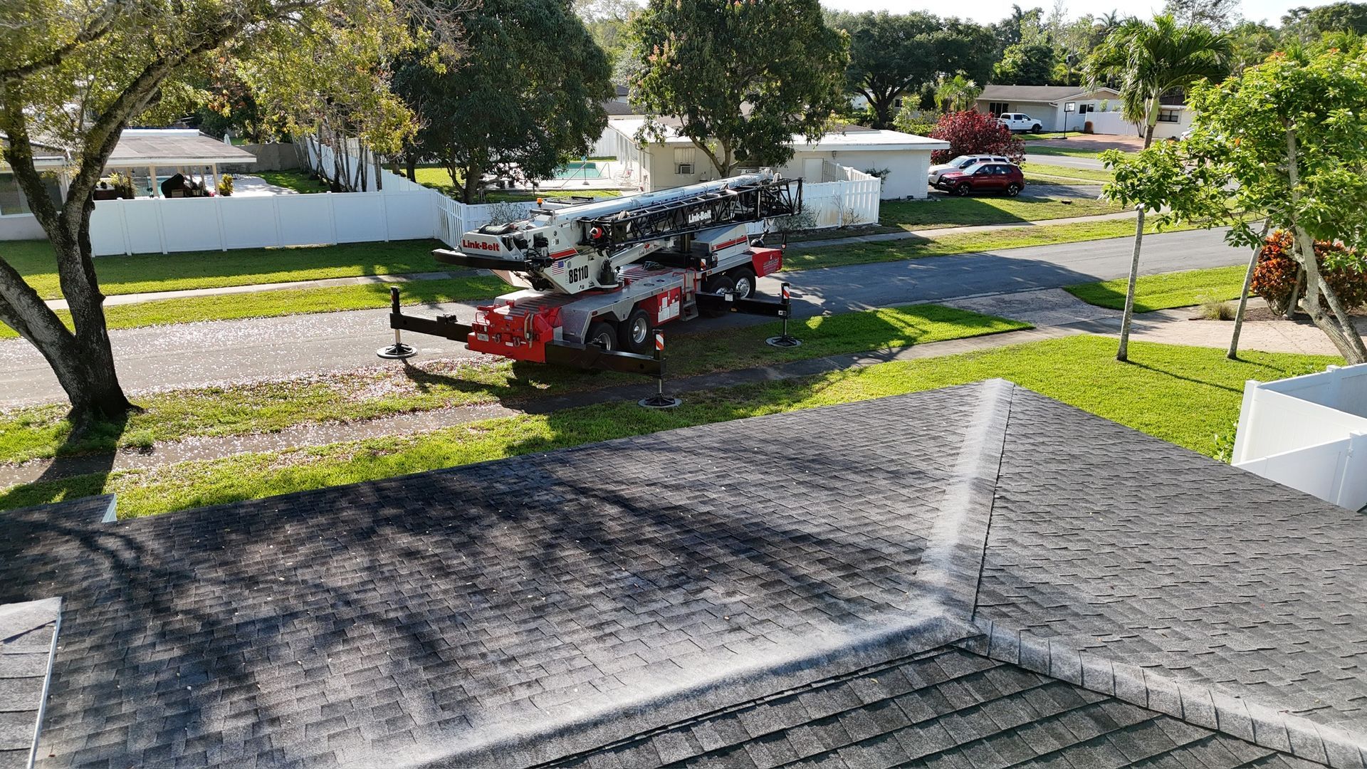 An aerial view of a roof cleaning machine in a residential area.