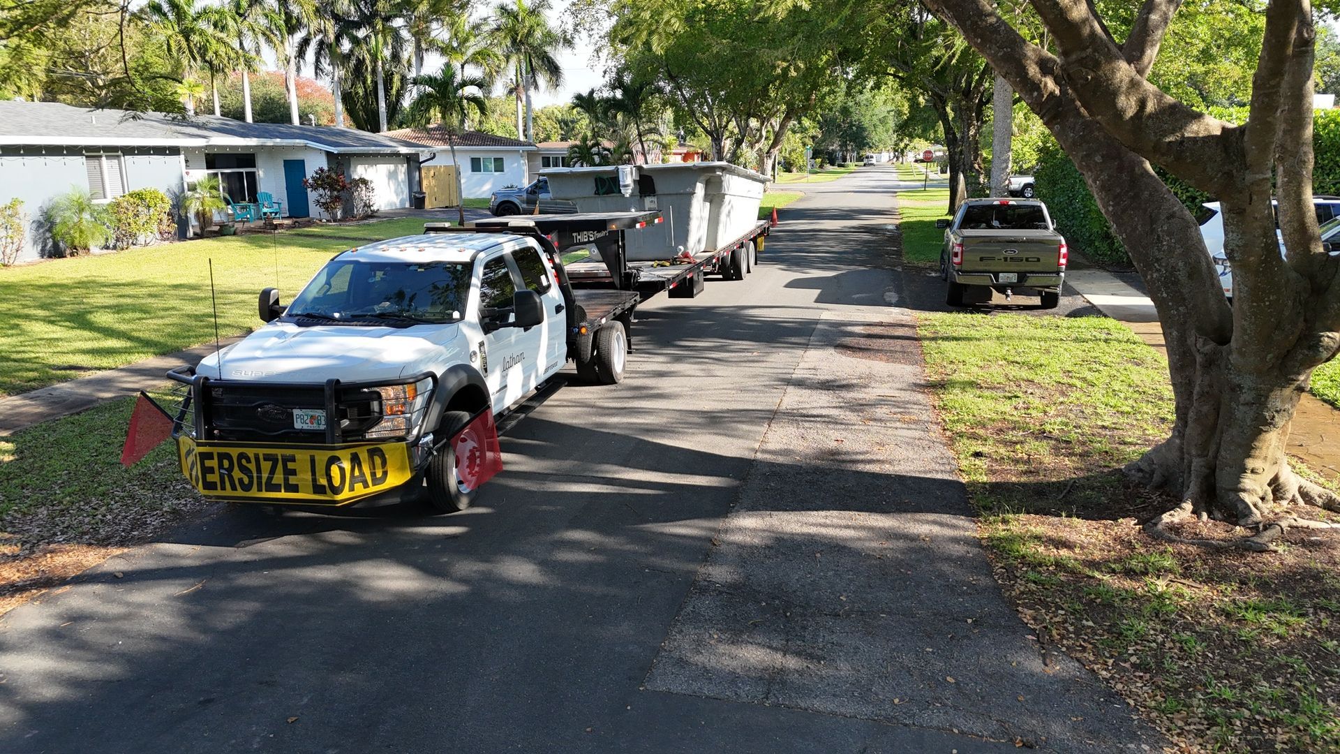 A white truck with a yellow sign on the front that says website lot j.