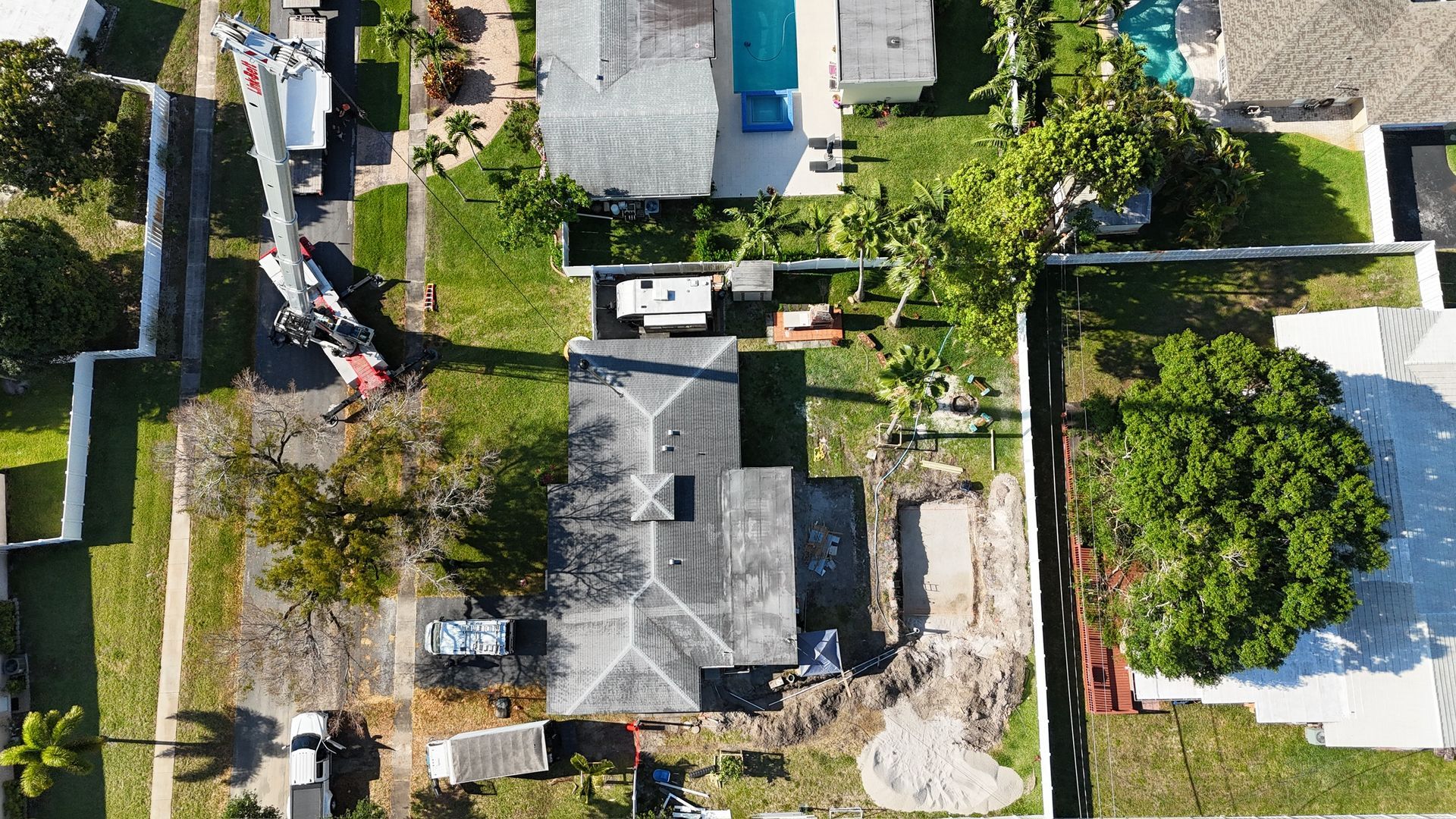 An aerial view of a residential area with houses and a pool.