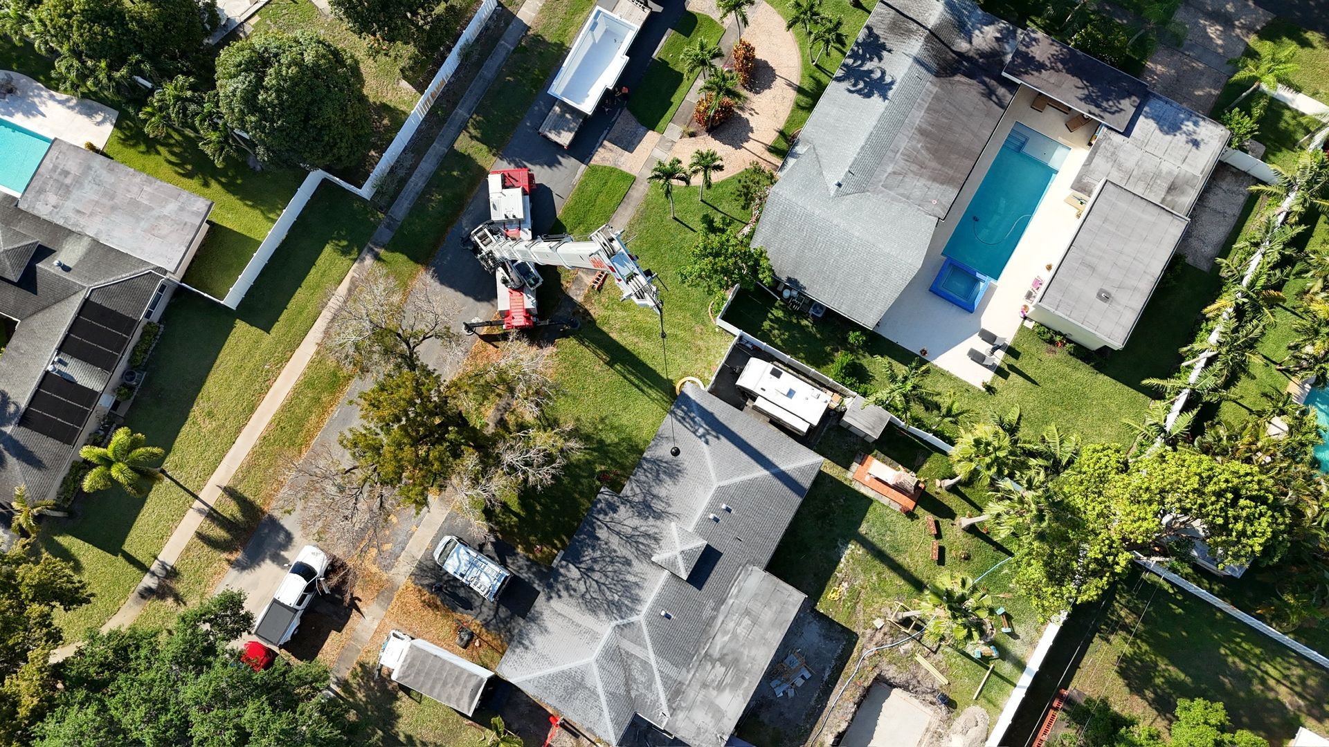 An aerial view of a residential area with houses and a pool.