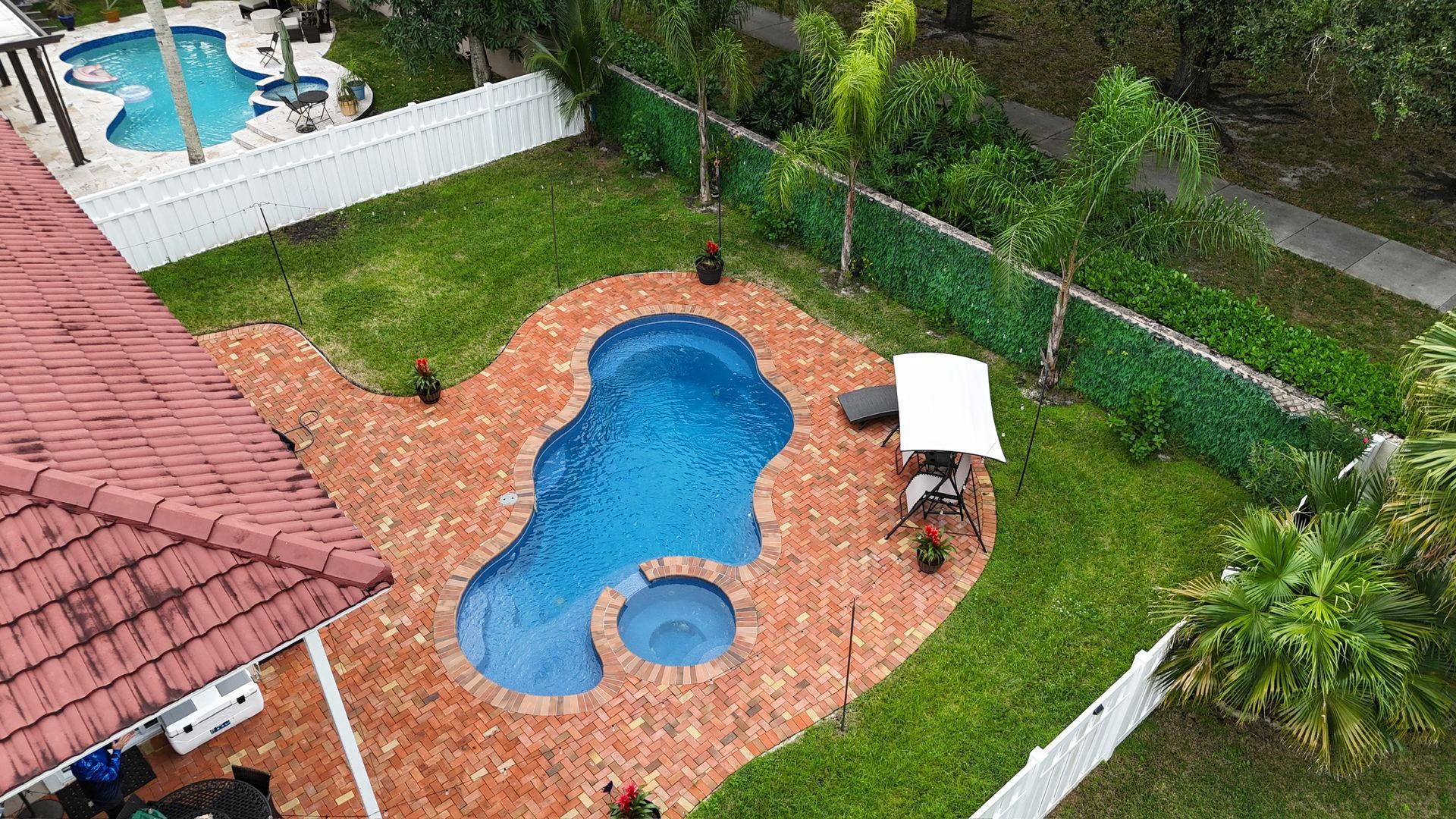 An aerial view of a swimming pool in the backyard of a house.