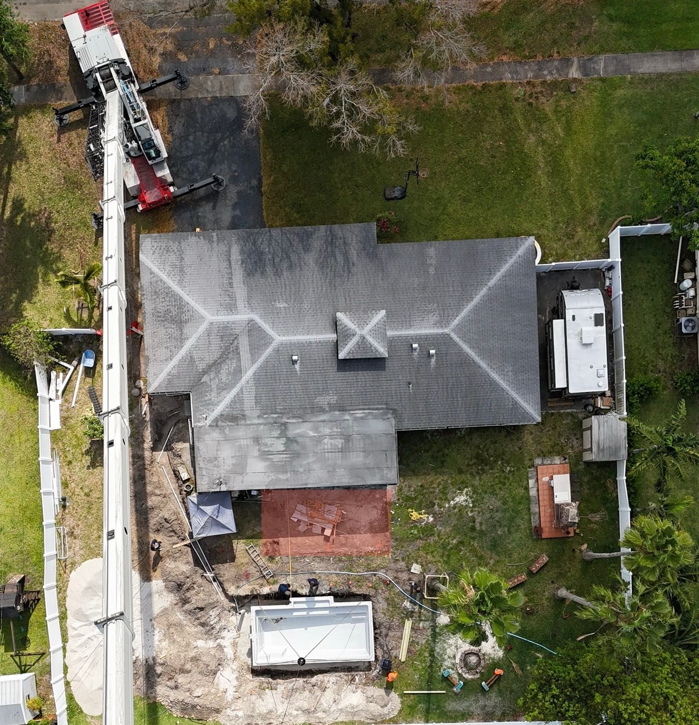 An aerial view of a house with a crane in front of it