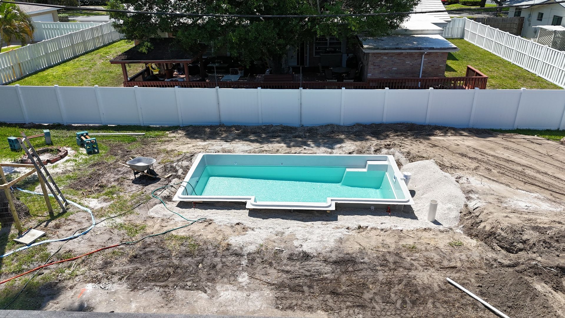 An aerial view of a swimming pool being built in a backyard.