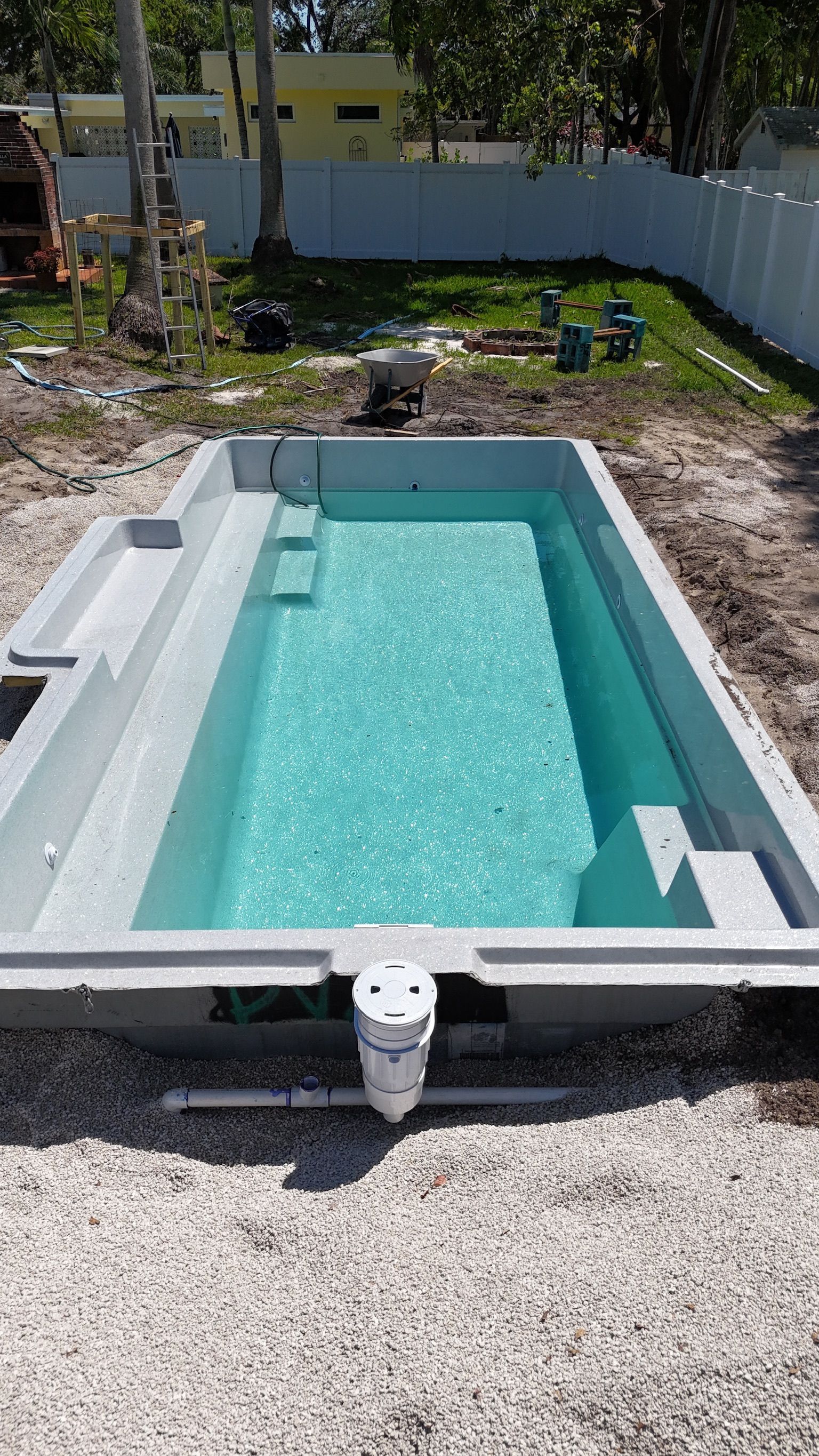 A swimming pool is being built in a backyard.