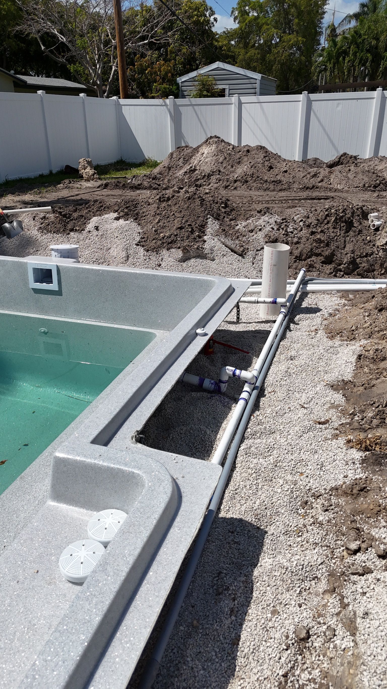 A swimming pool is being built in a backyard.