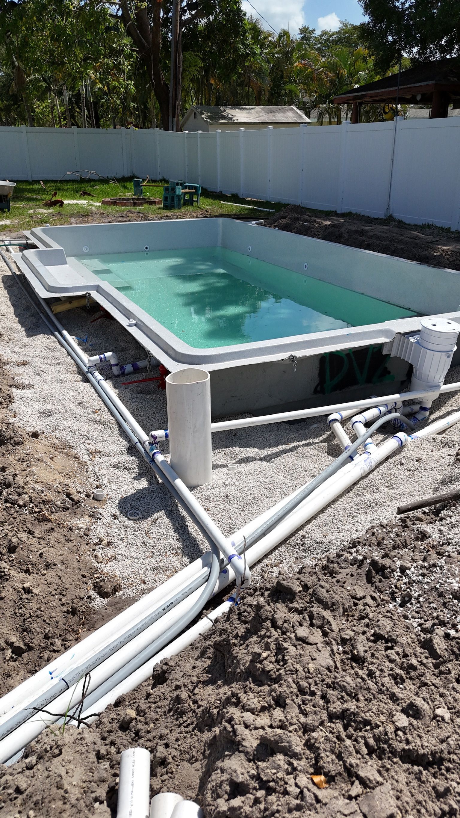 A swimming pool is being built in a backyard.