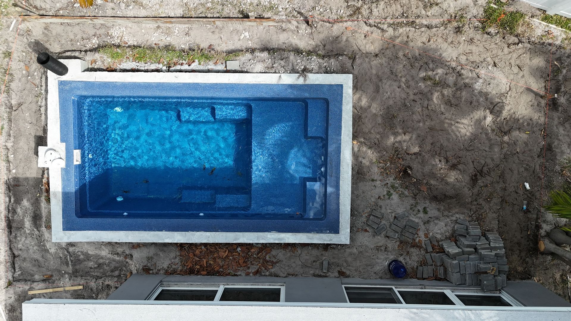 An aerial view of a large swimming pool in a backyard.