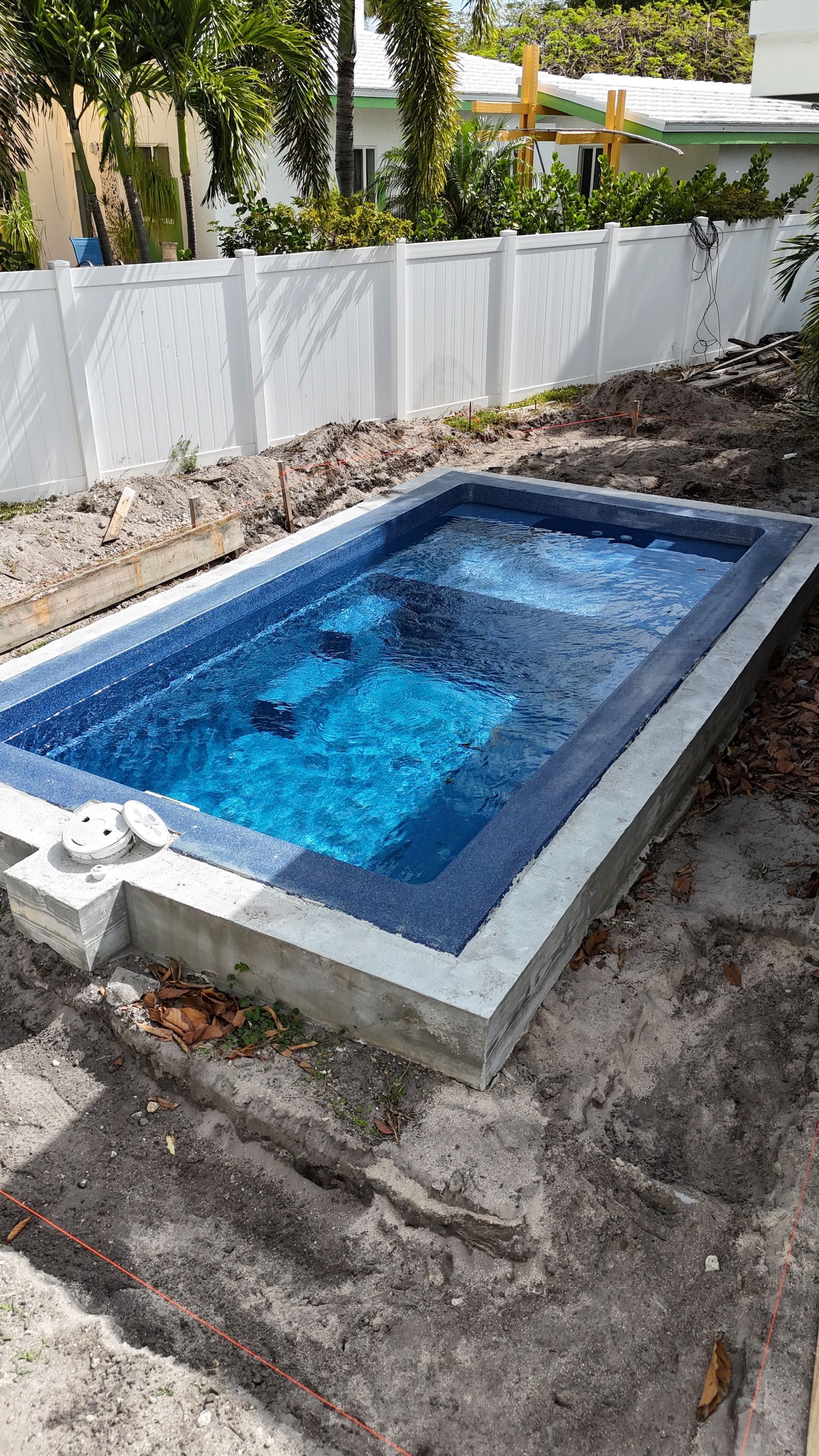 A small swimming pool is being built in a backyard.