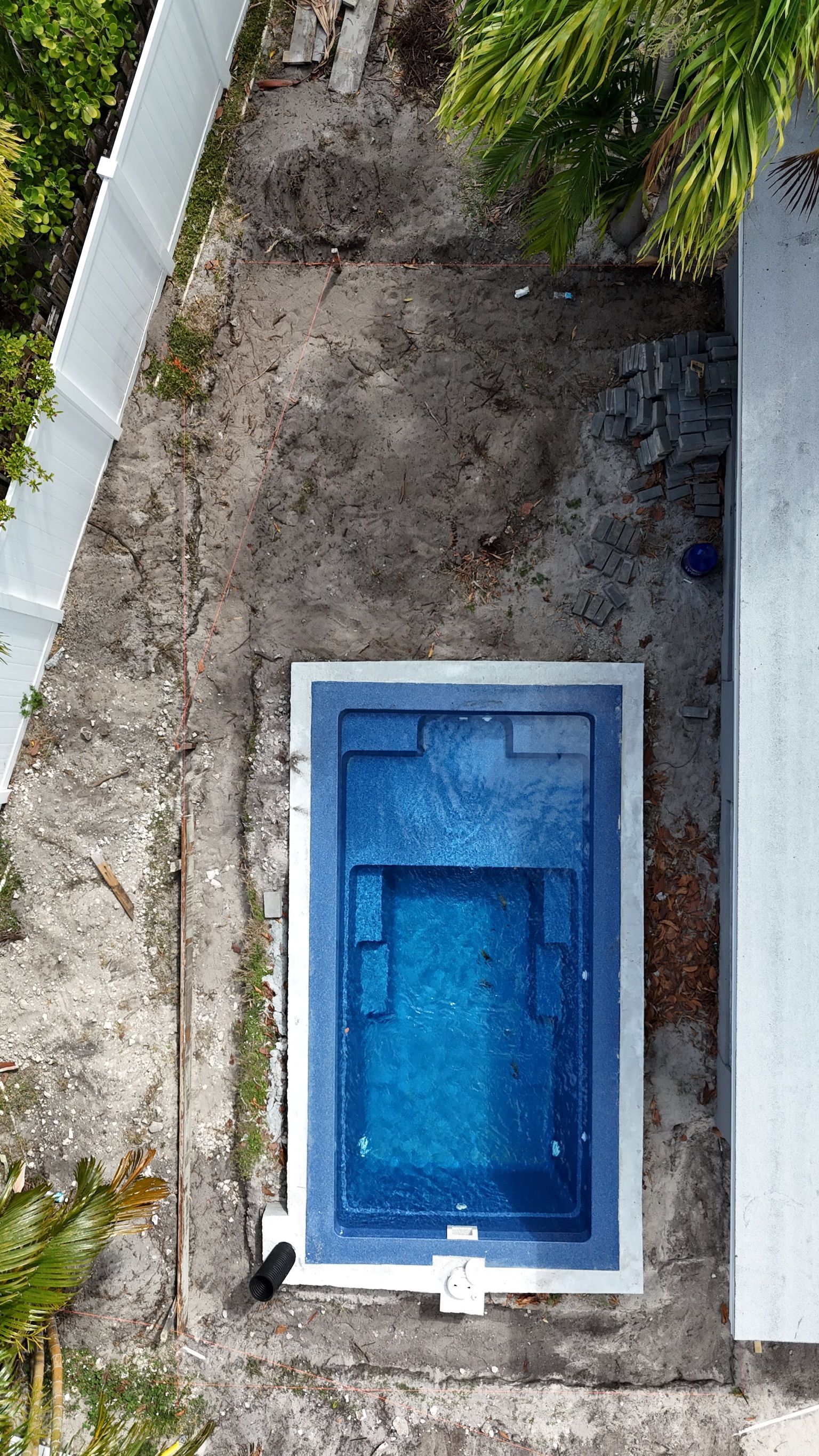 An aerial view of a small swimming pool in a backyard.