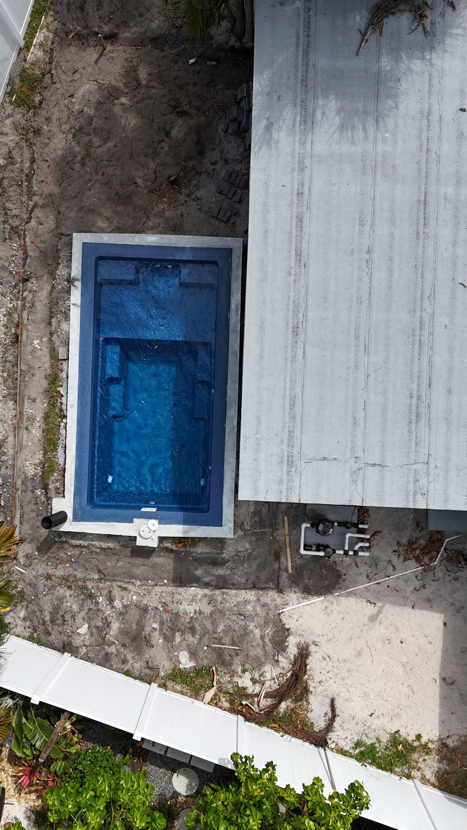 An aerial view of a swimming pool in the backyard of a house.