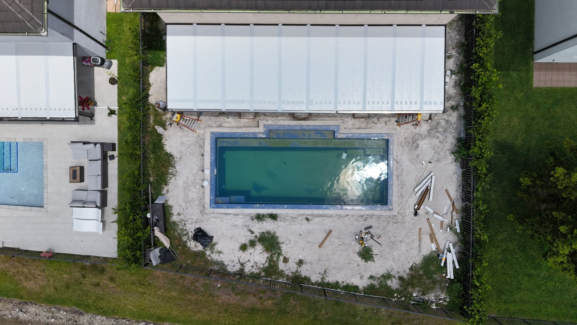 An aerial view of a house with a swimming pool in the backyard