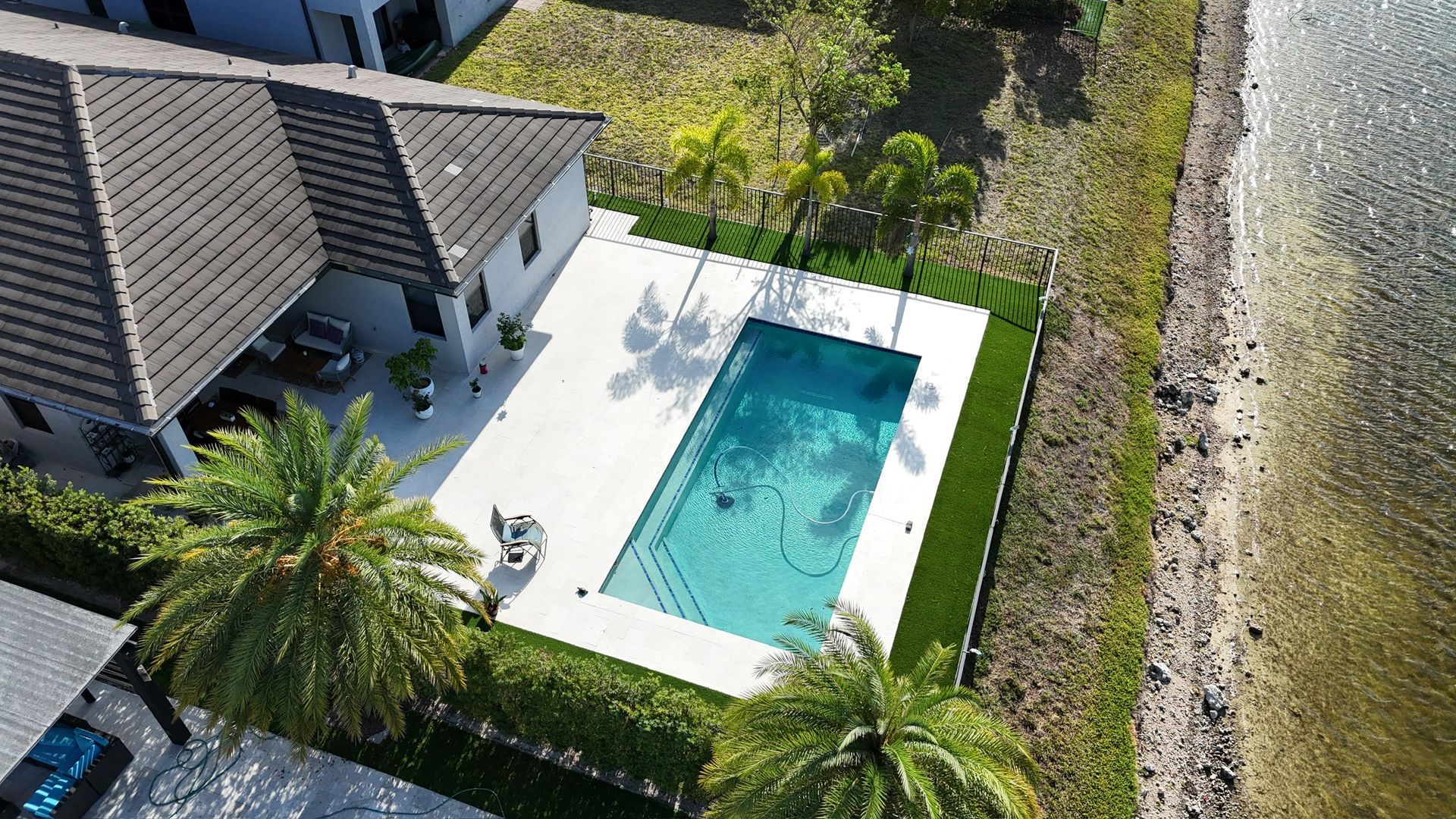 An aerial view of a swimming pool in the backyard of a house.