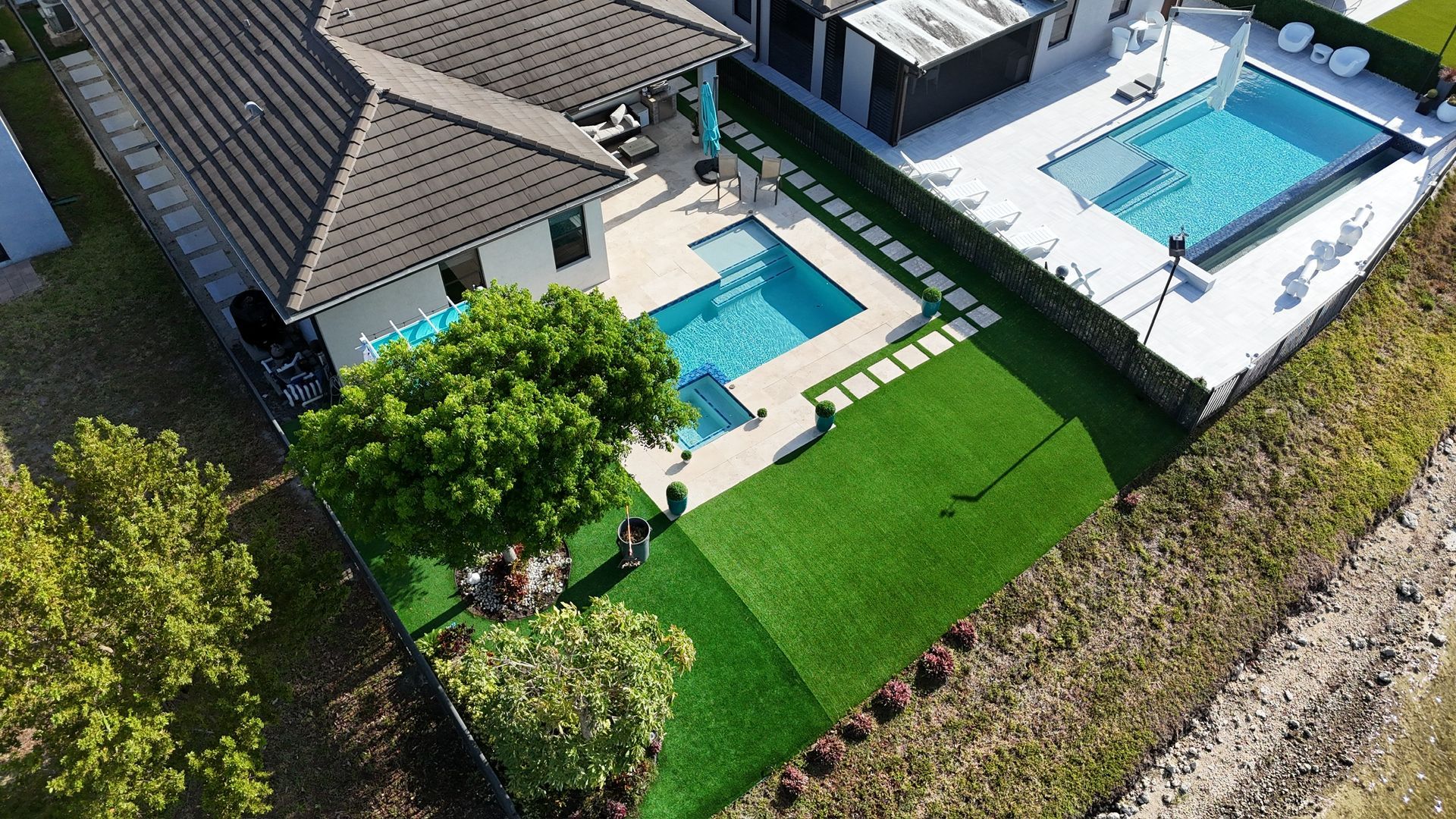 An aerial view of a house with a swimming pool in the backyard.