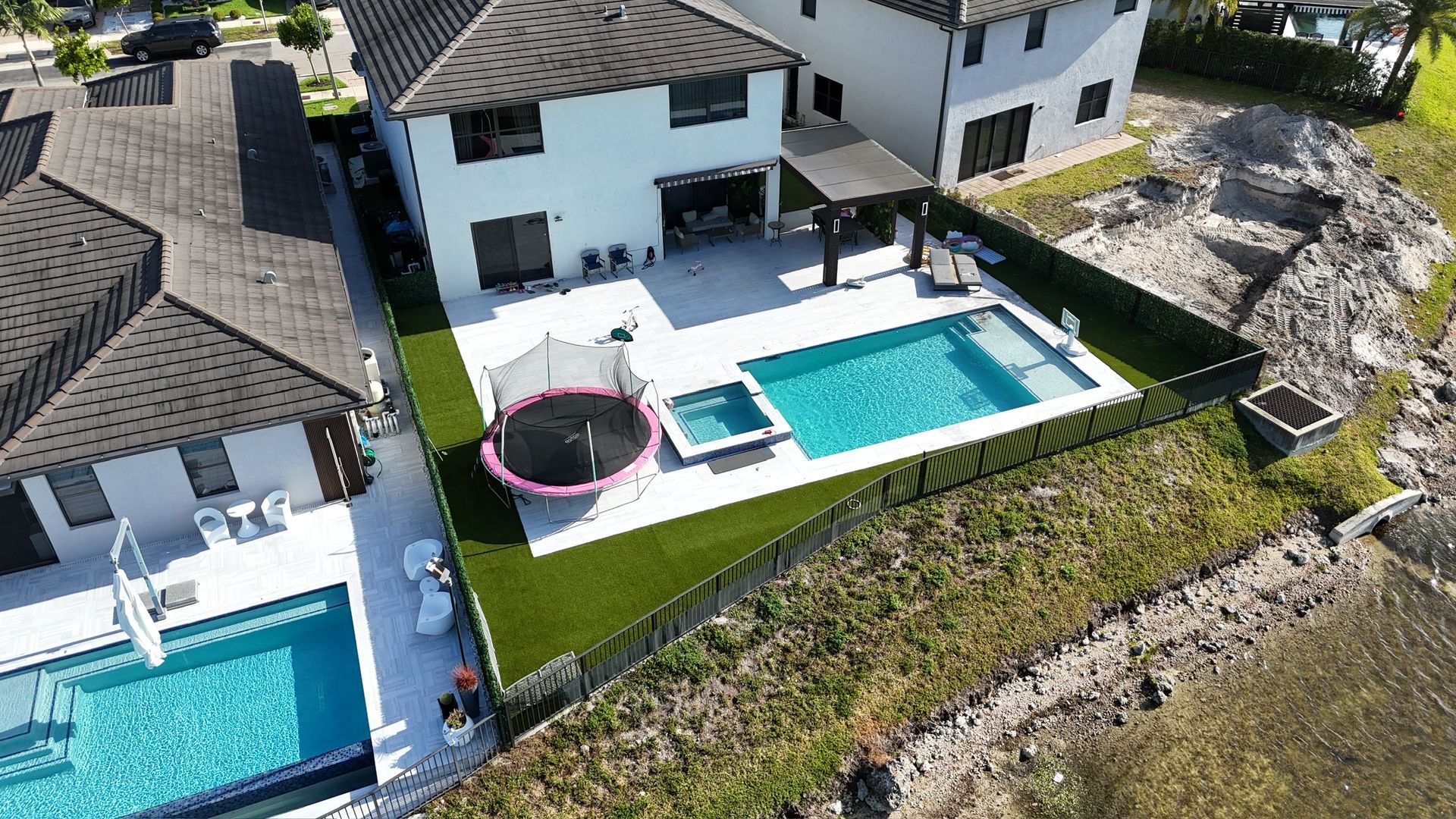 An aerial view of a house with a large swimming pool in the backyard.