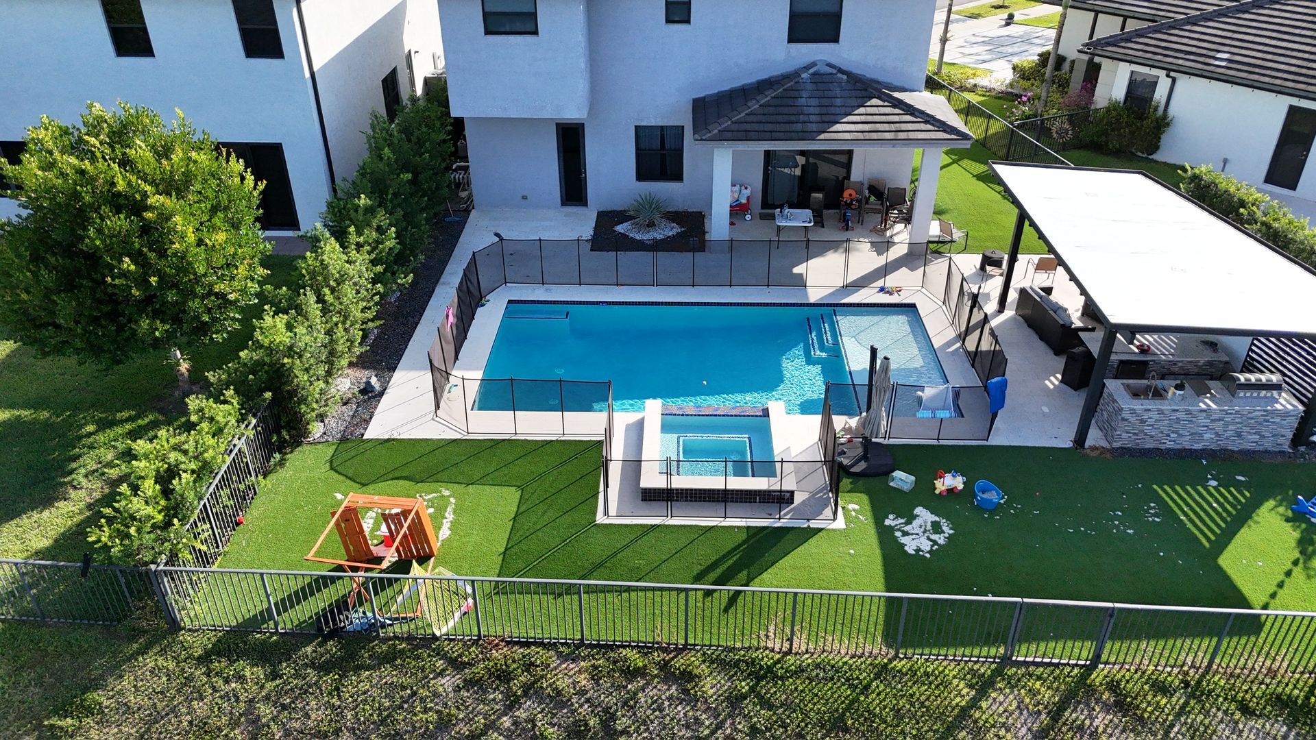 An aerial view of a house with a large swimming pool