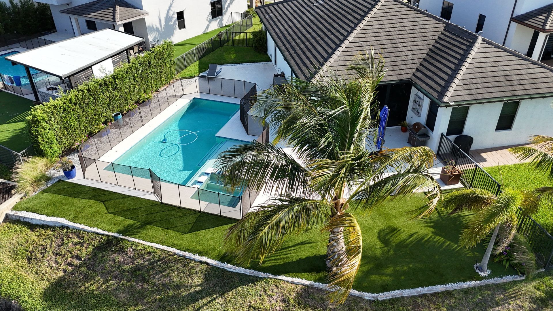 An aerial view of a house with a swimming pool in the backyard.