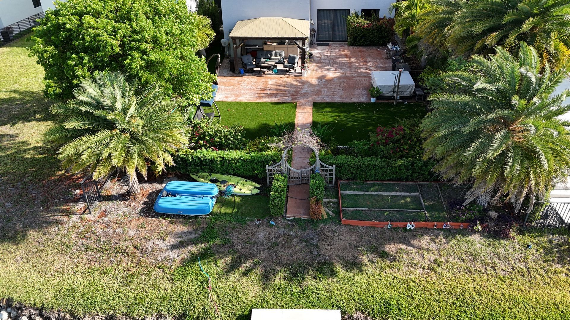 An aerial view of a house and a lush green yard.