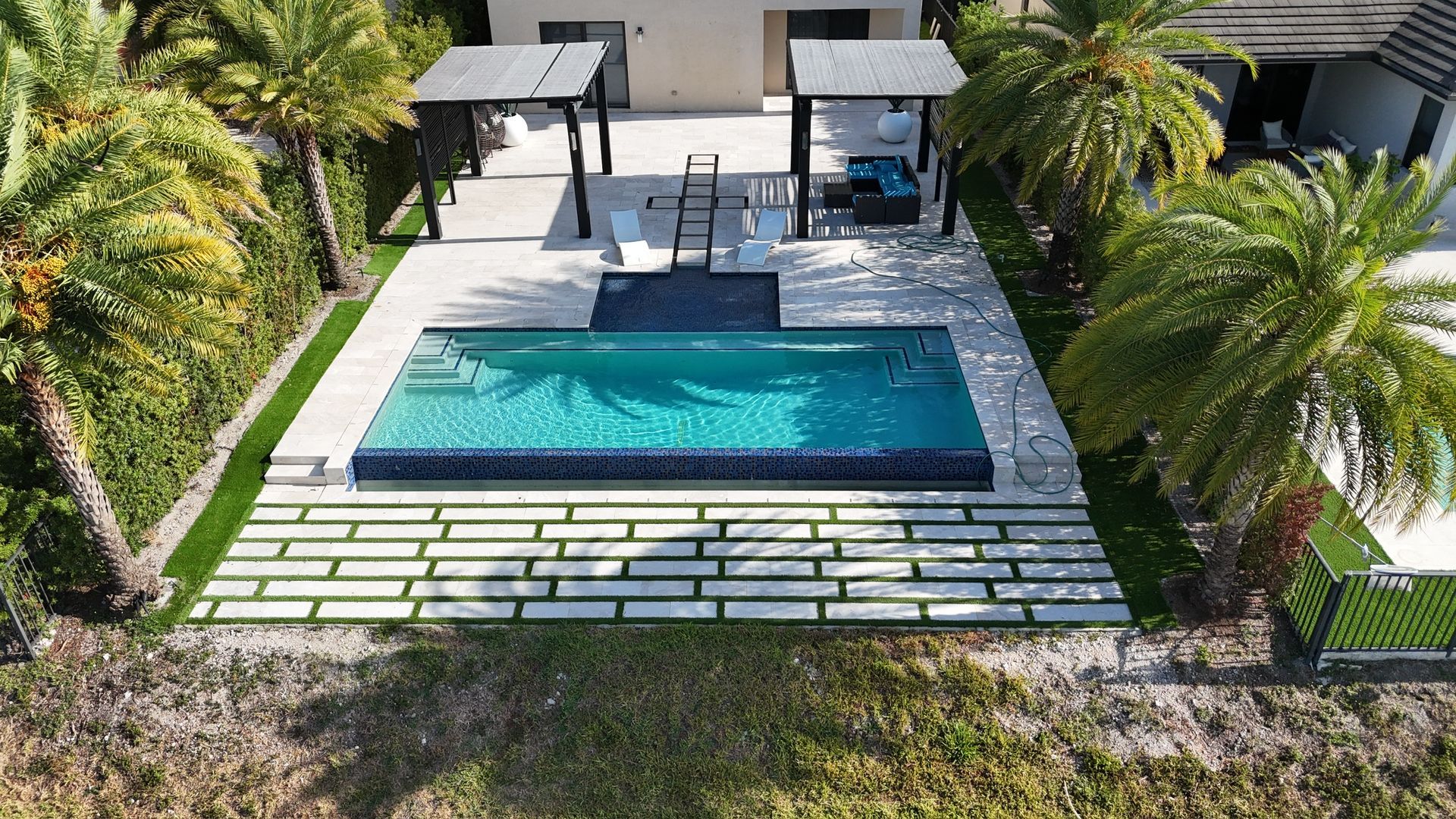An aerial view of a large swimming pool surrounded by palm trees.