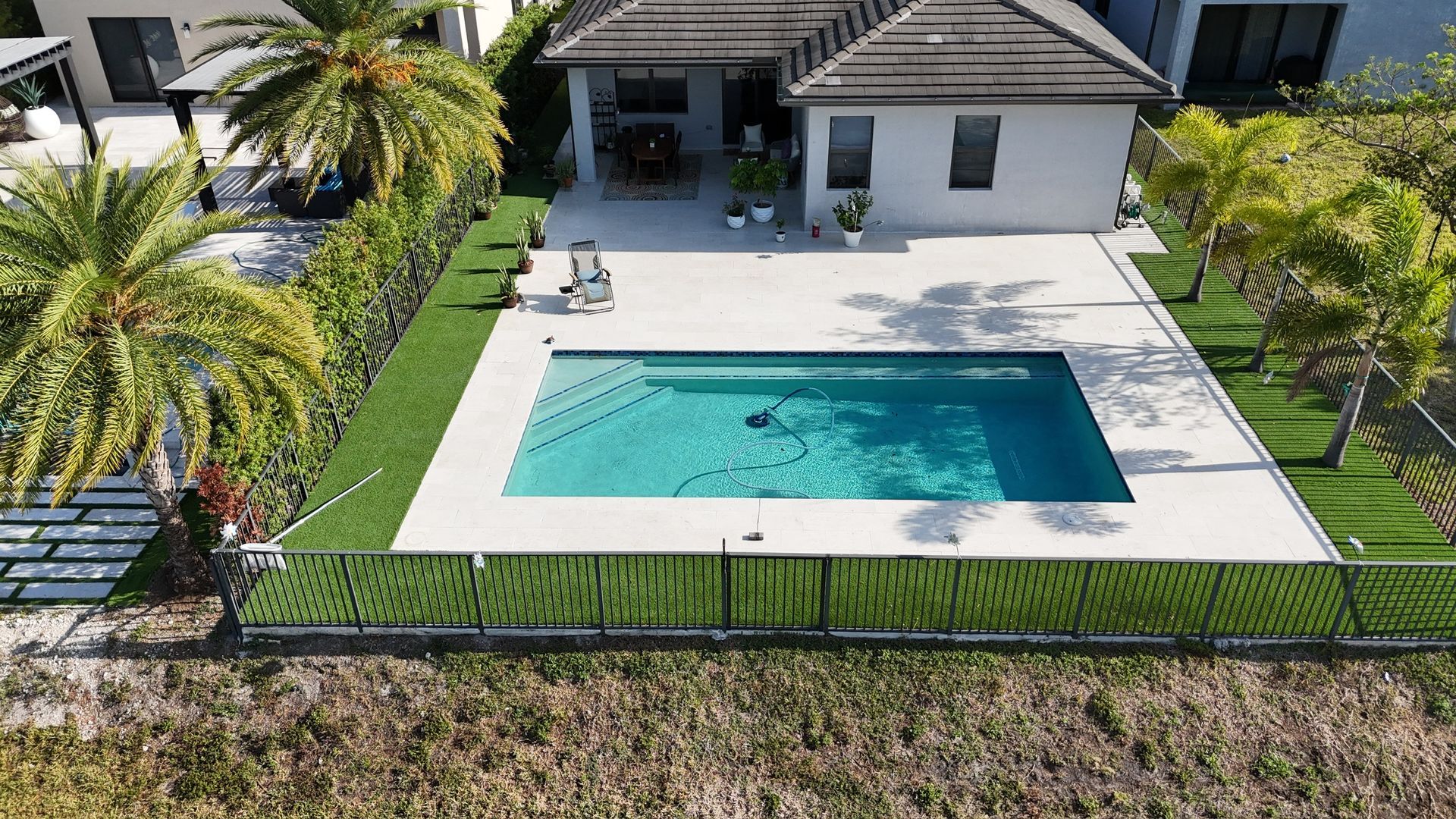An aerial view of a house with a large swimming pool