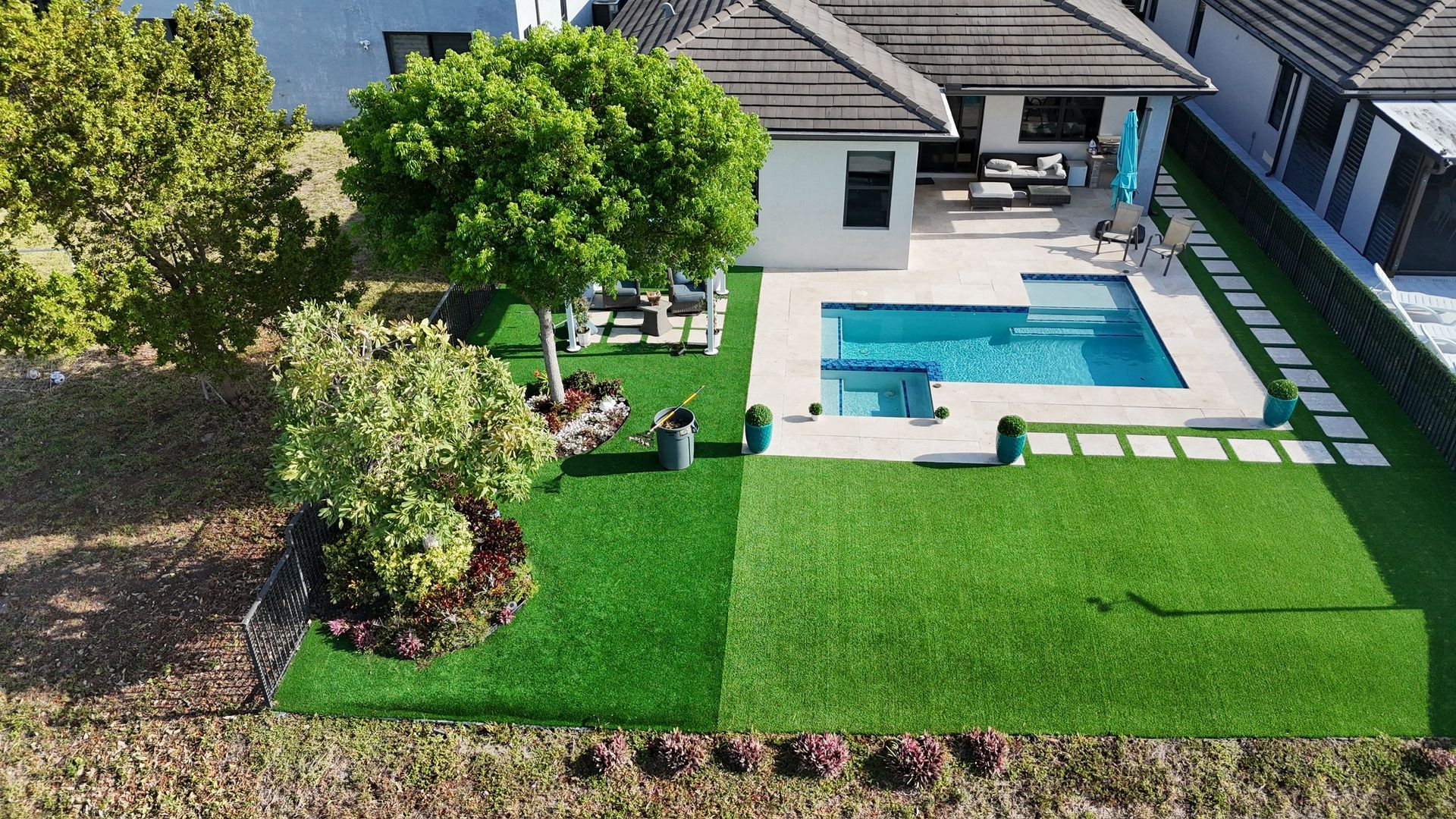 An aerial view of a house with a swimming pool in the backyard.