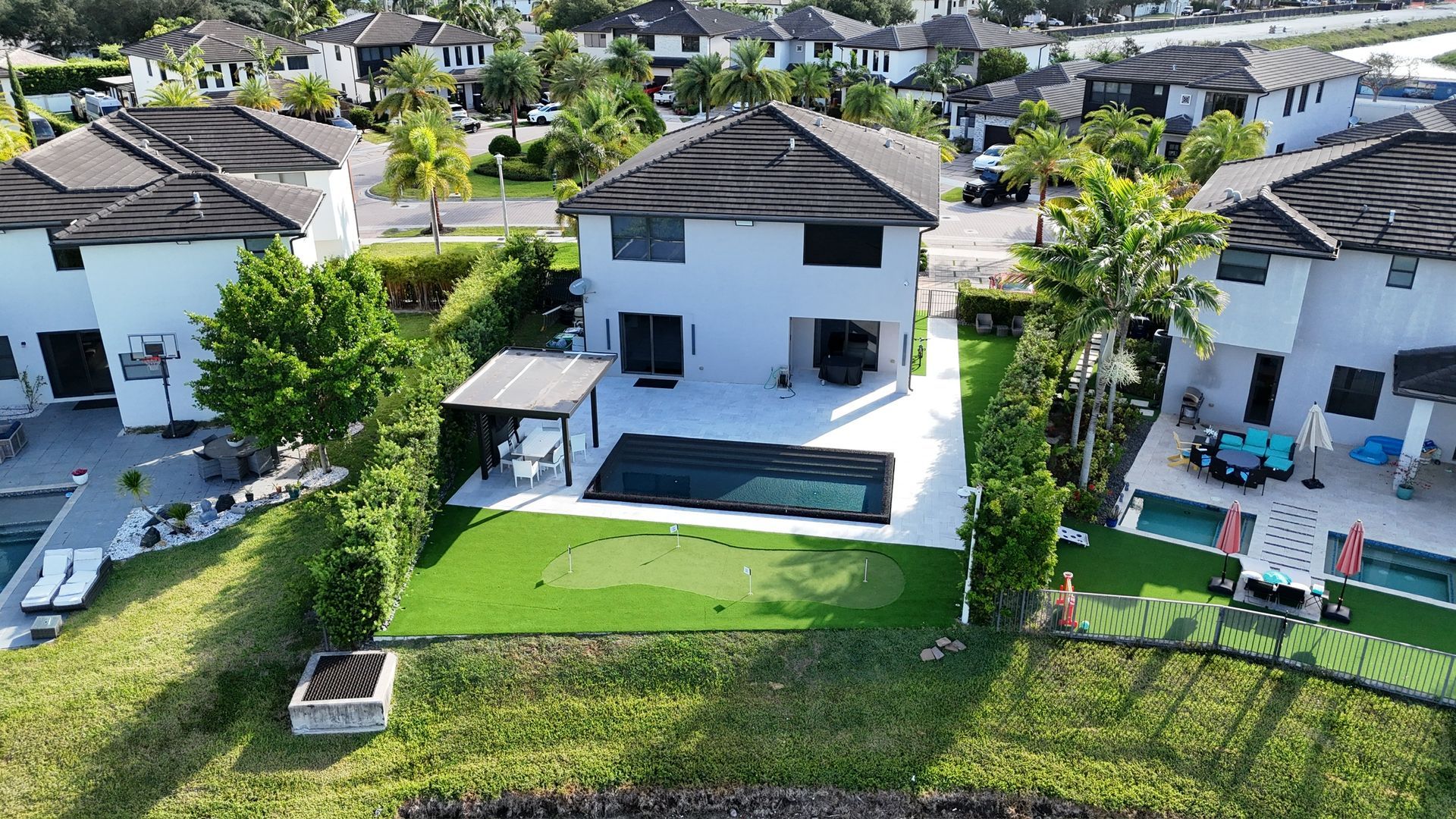 An aerial view of a house with a pool in a residential area.