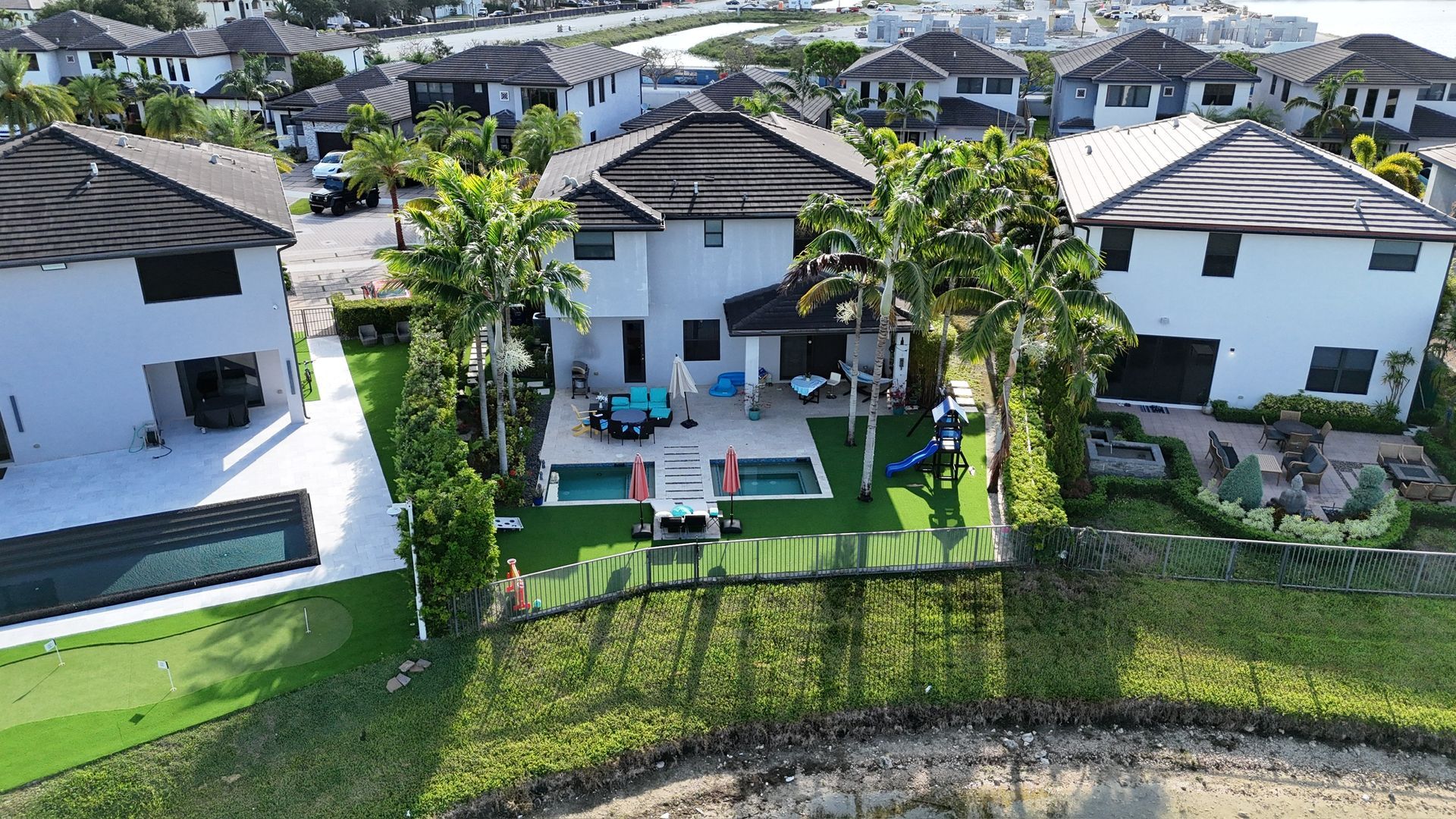 An aerial view of a residential area with houses and a pool