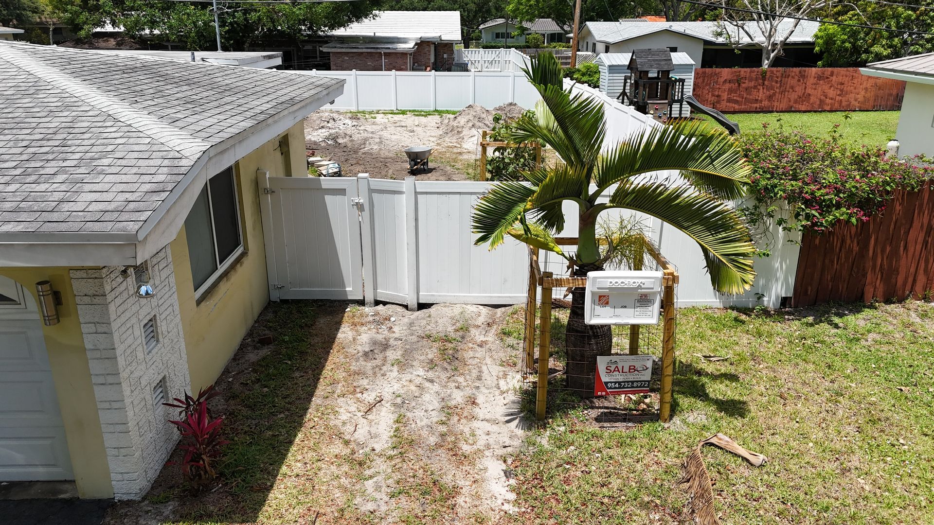 An aerial view of a house with a palm tree in front of it.