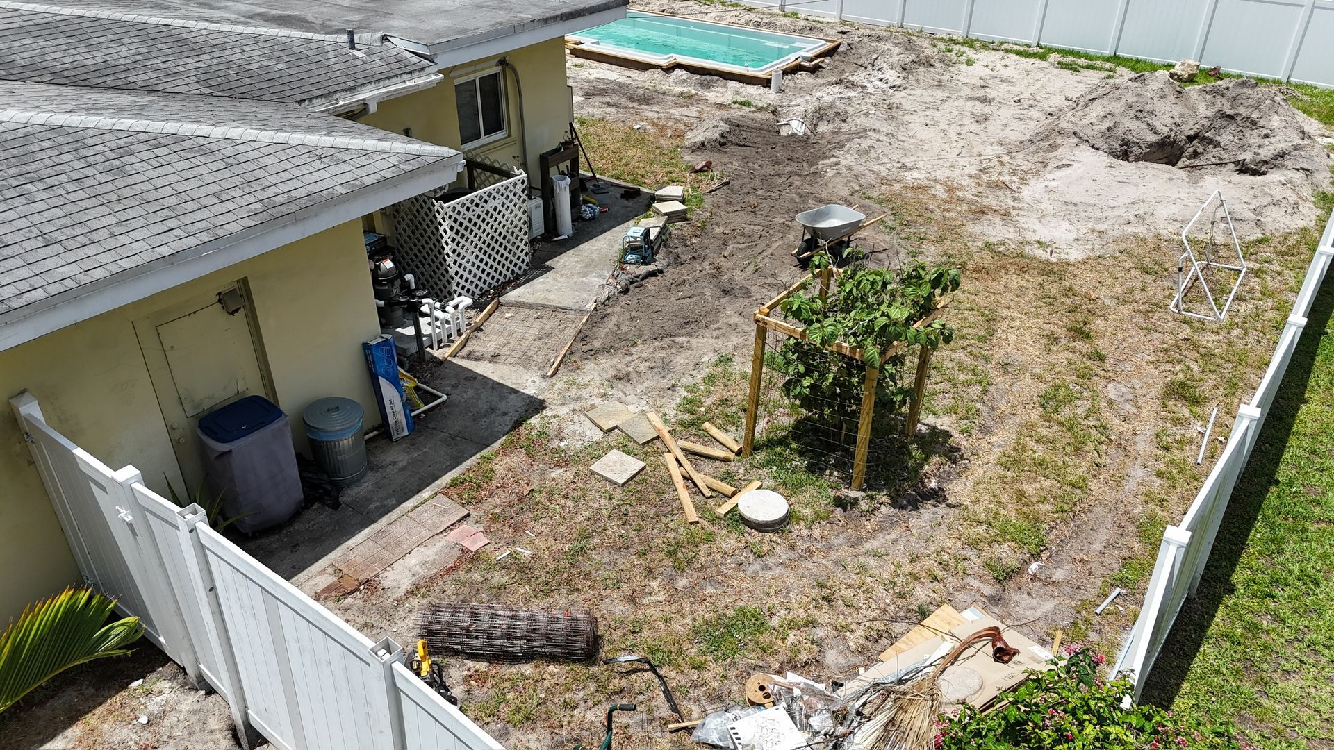 An aerial view of a house and backyard with a pool in the background.