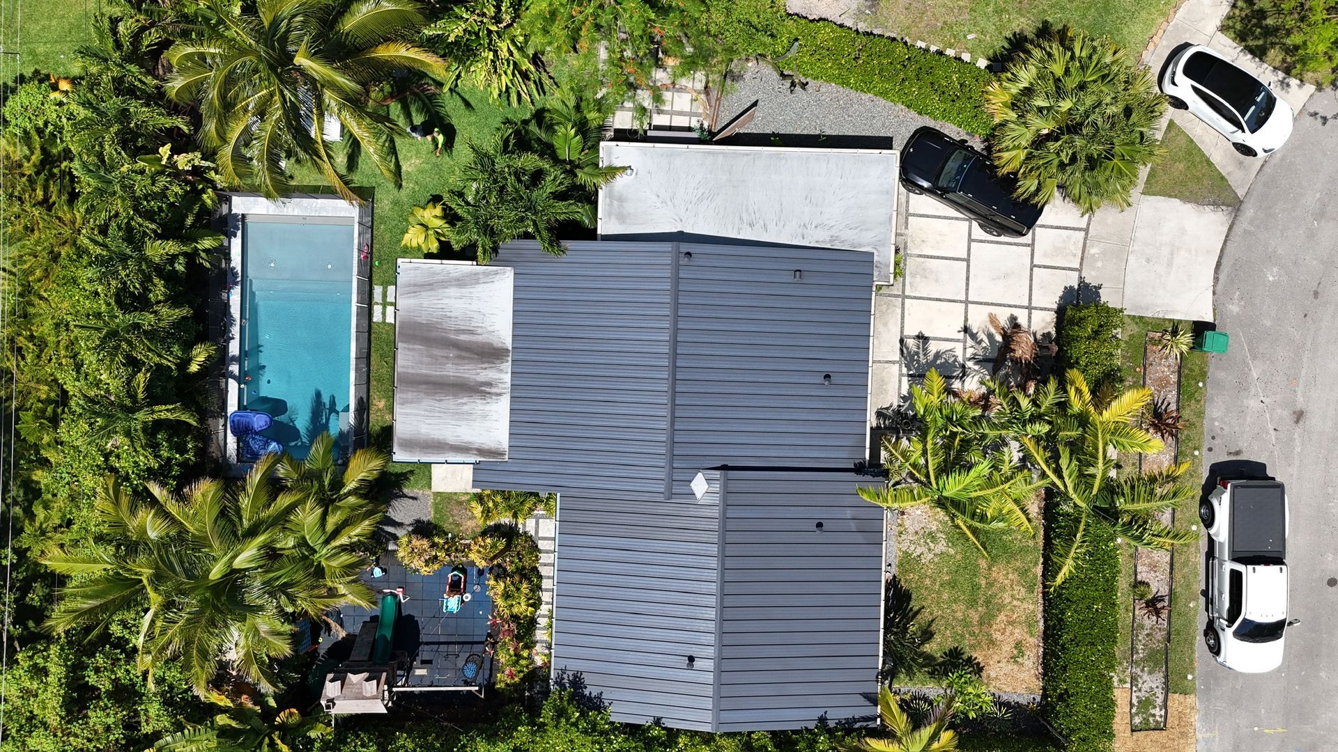 An aerial view of a house with a pool and a car parked in front of it.