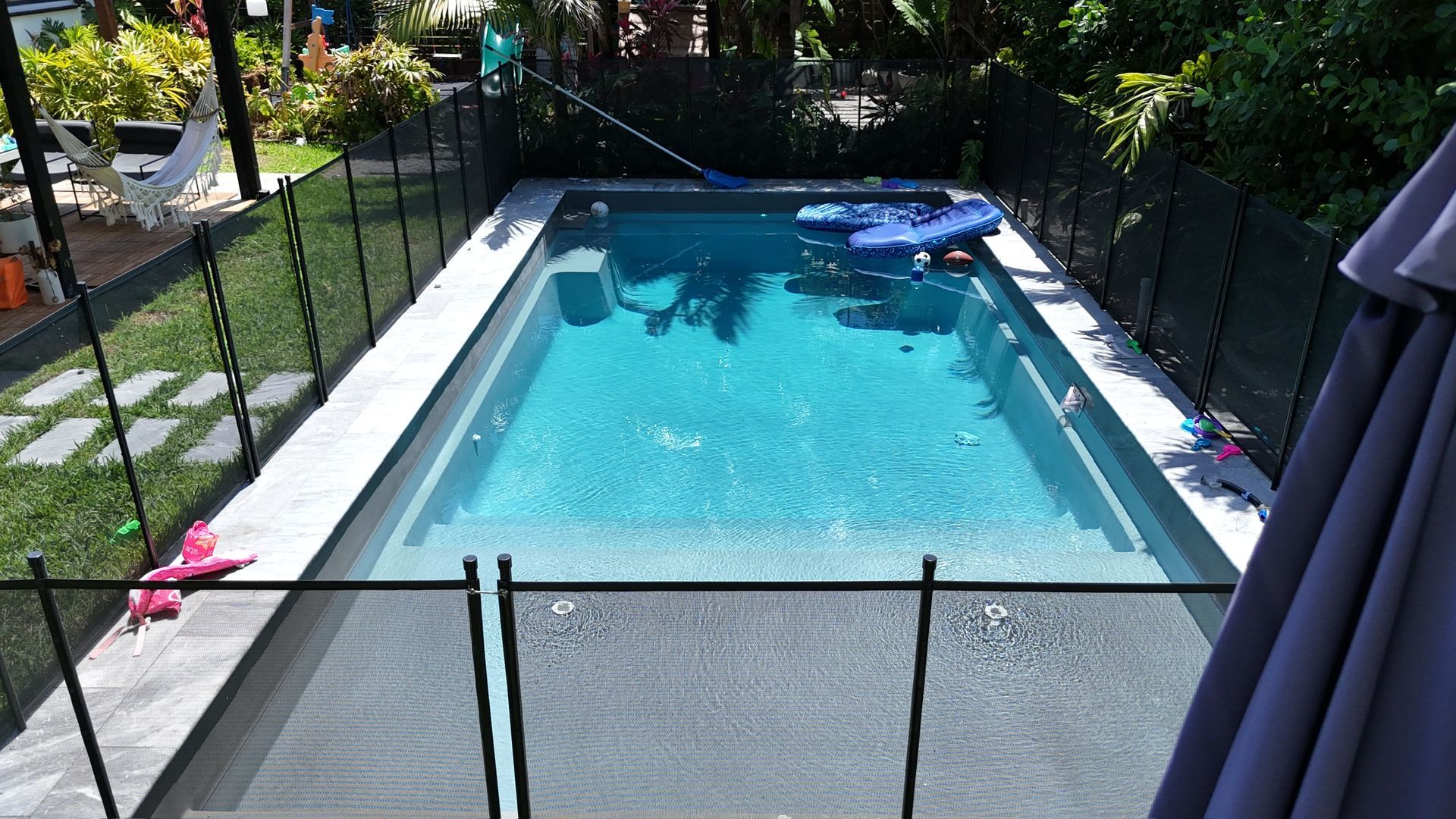 A large swimming pool with a fence around it