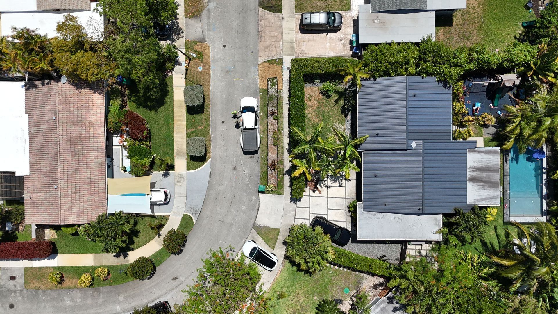 An aerial view of a residential neighborhood with houses and a pool.