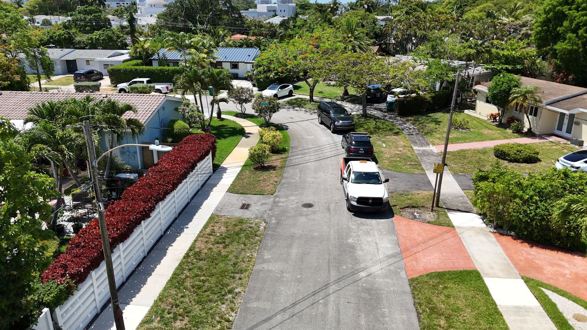 An aerial view of a residential neighborhood with a white truck parked on the side of the road.
