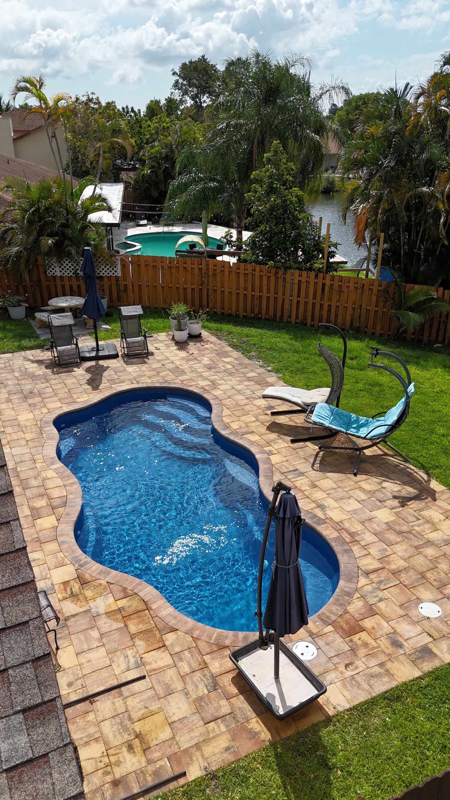 An aerial view of a large swimming pool in a backyard.