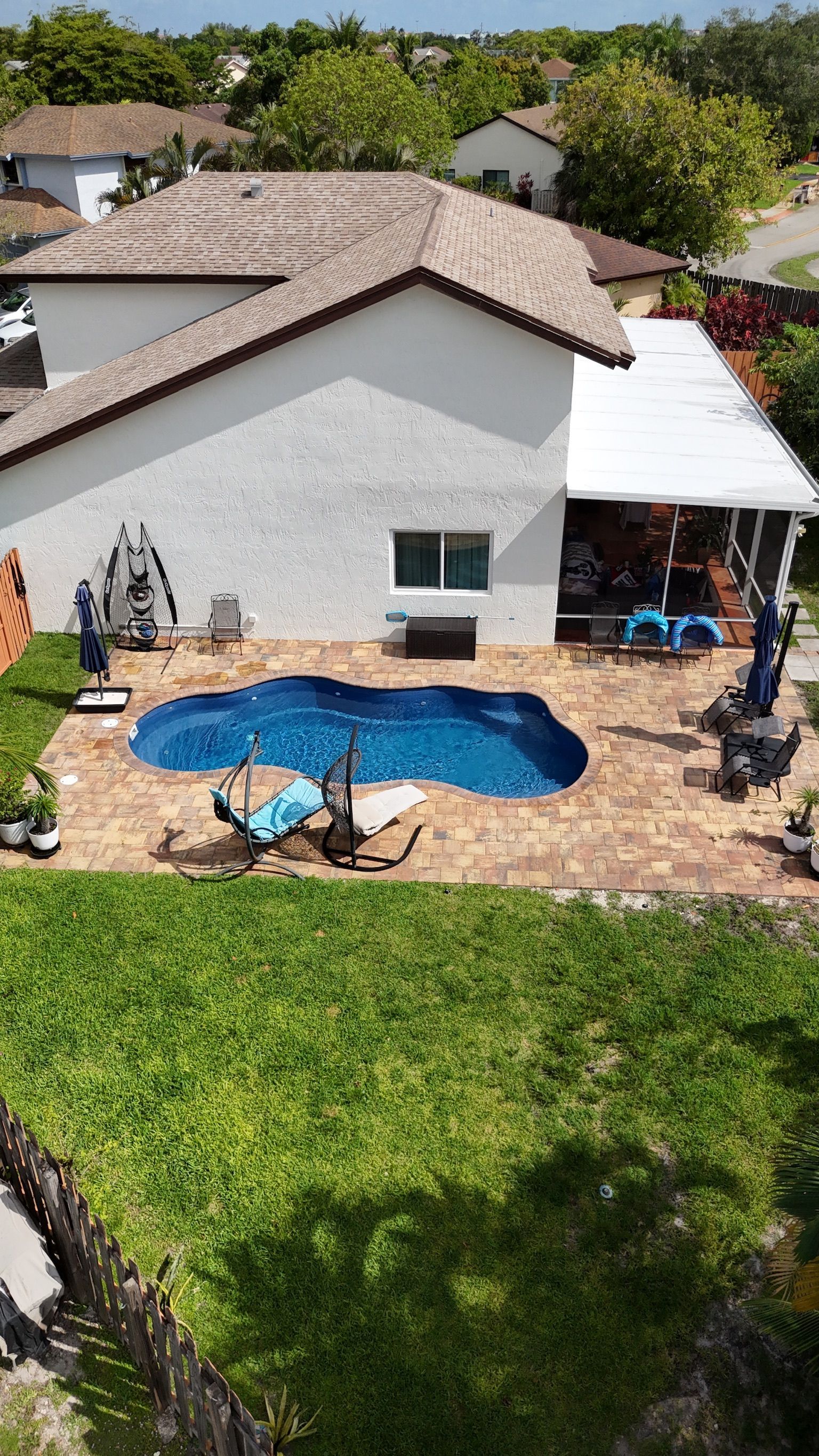 An aerial view of a house with a swimming pool in the backyard.