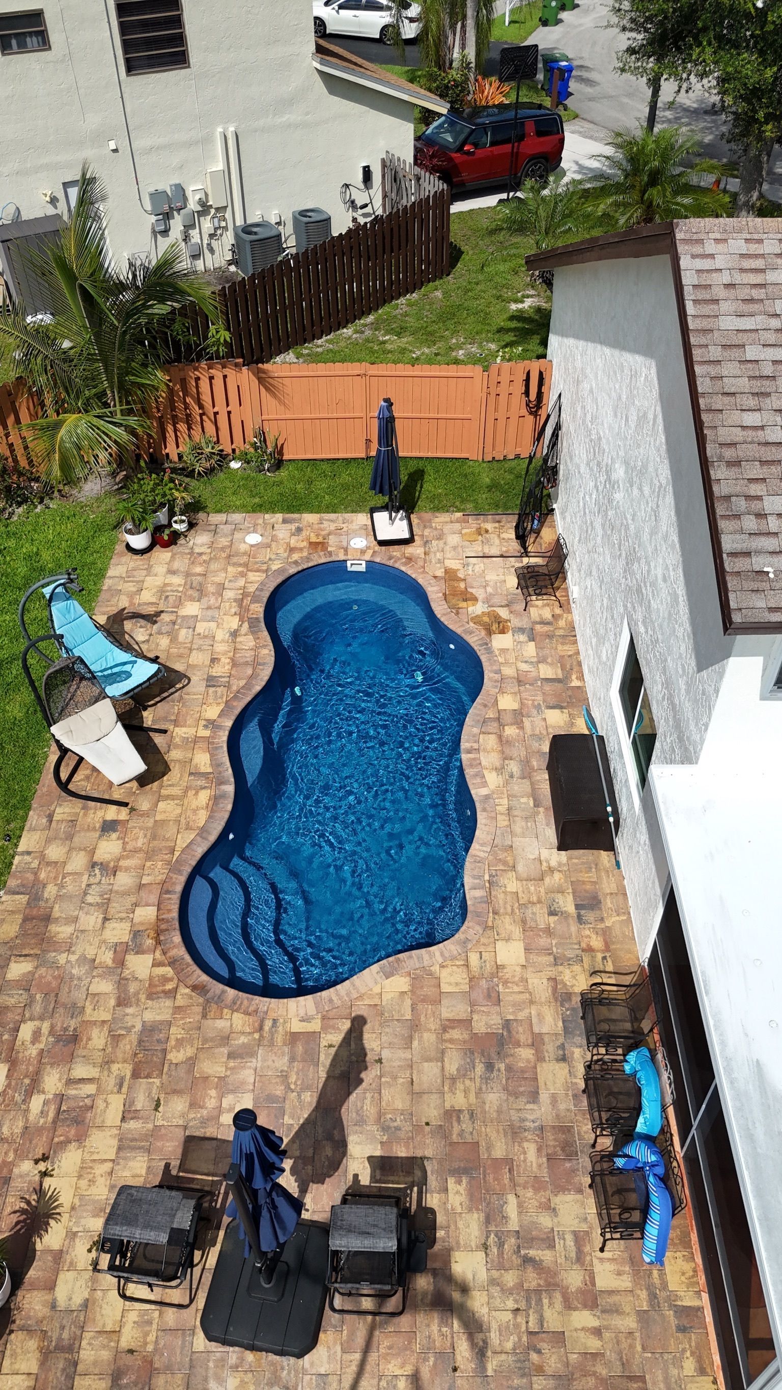 An aerial view of a large swimming pool in a backyard.