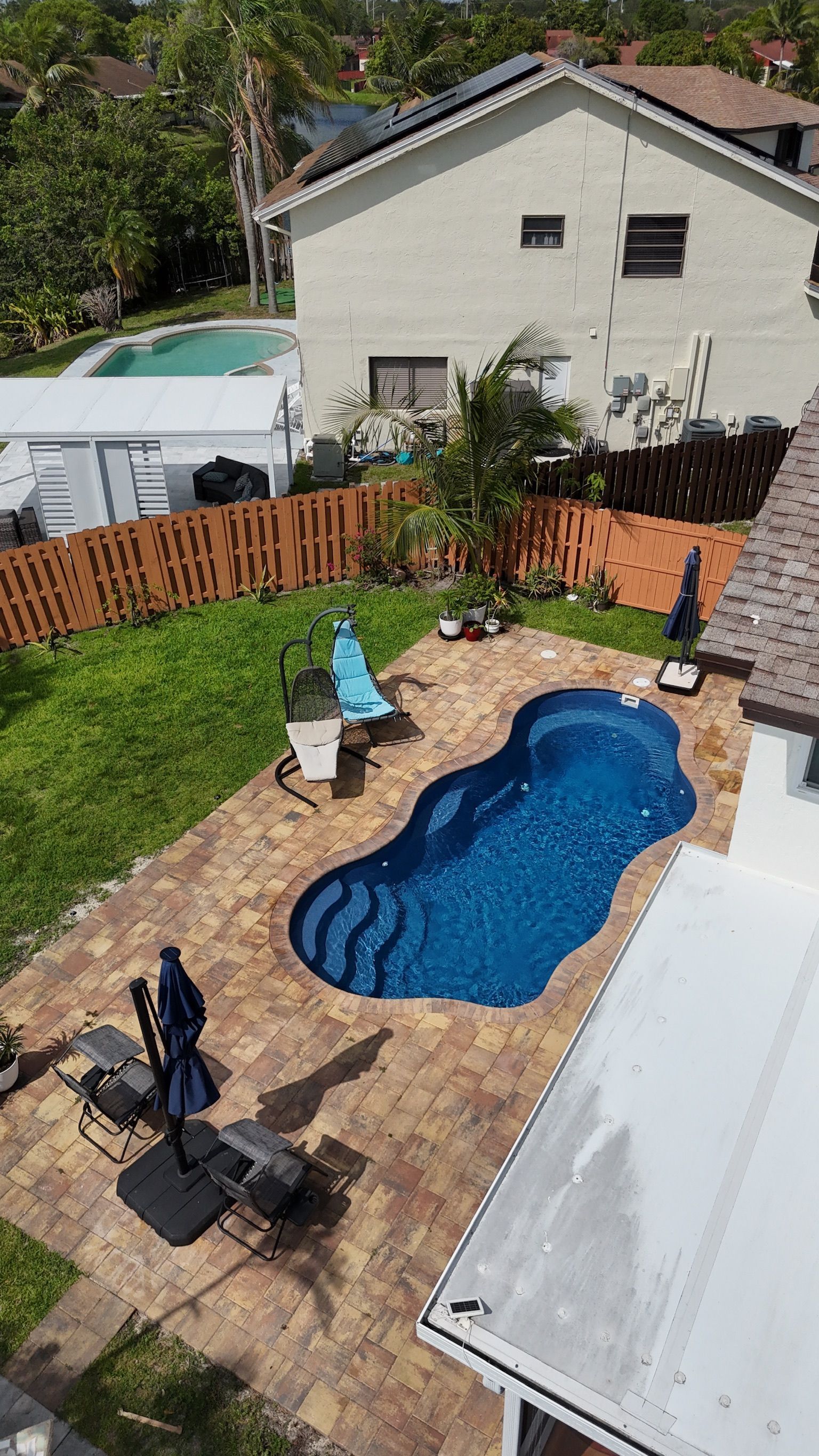 An aerial view of a backyard with a large swimming pool.