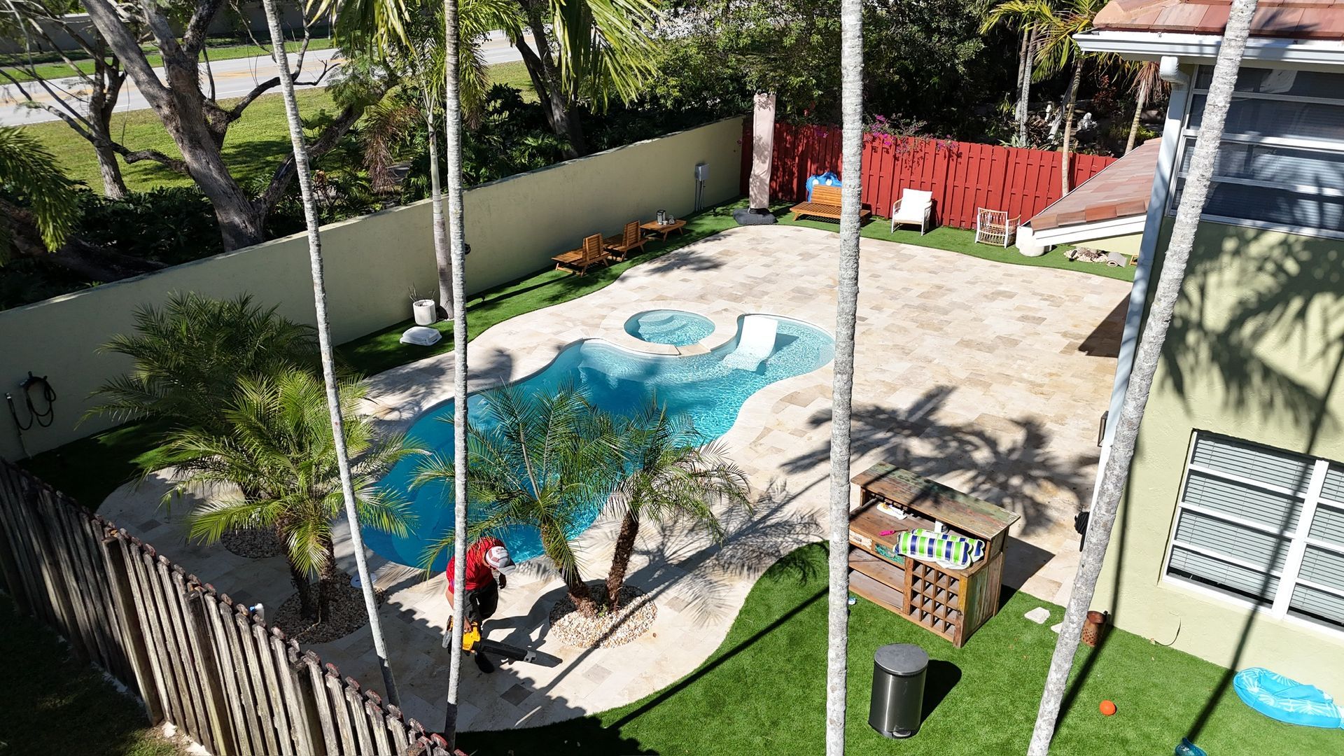 An aerial view of a backyard with a swimming pool and a house.